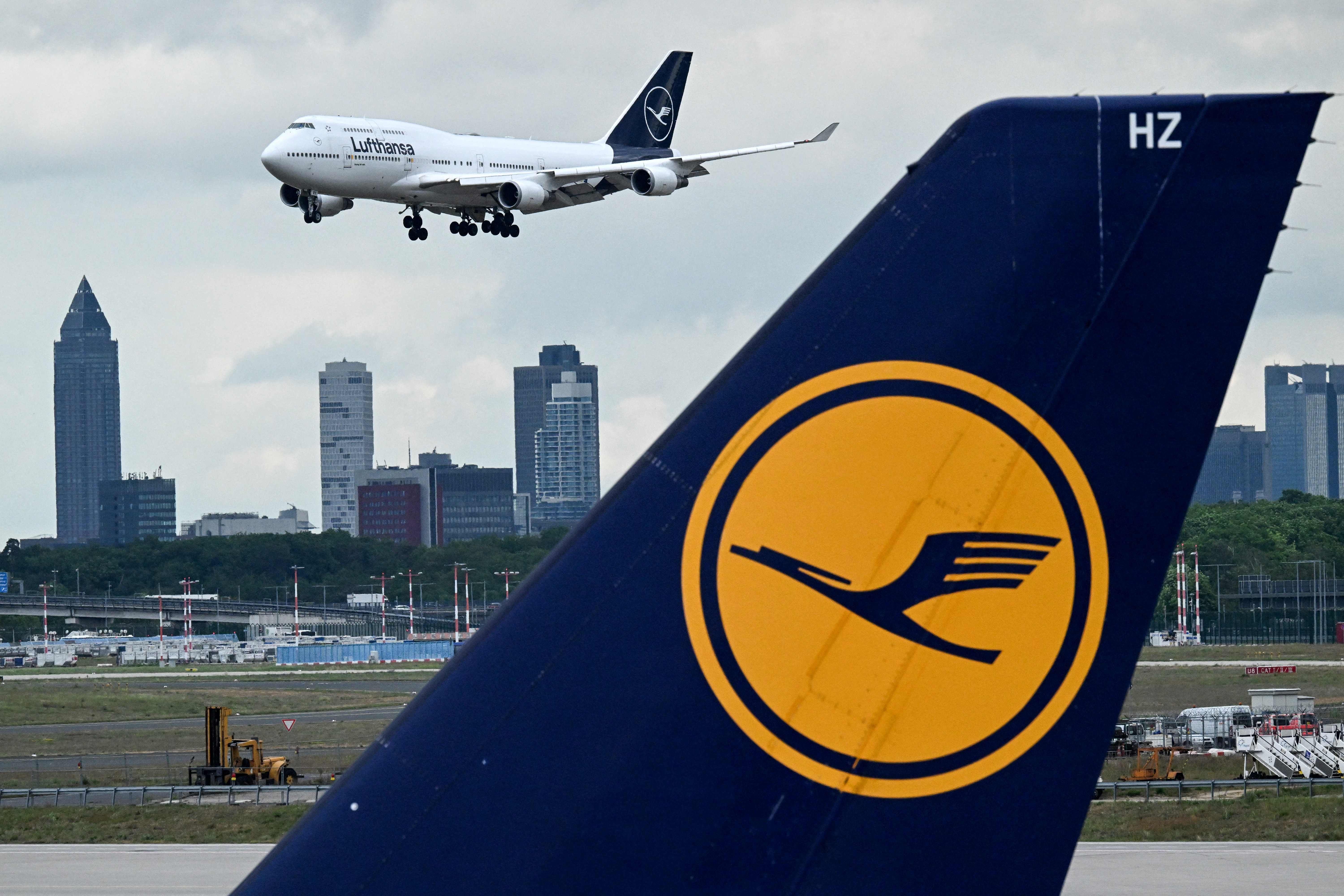 Eine Lufthansa Boeing 747 landet am Flughafen Frankfurt mit Skyline im Hintergrund.