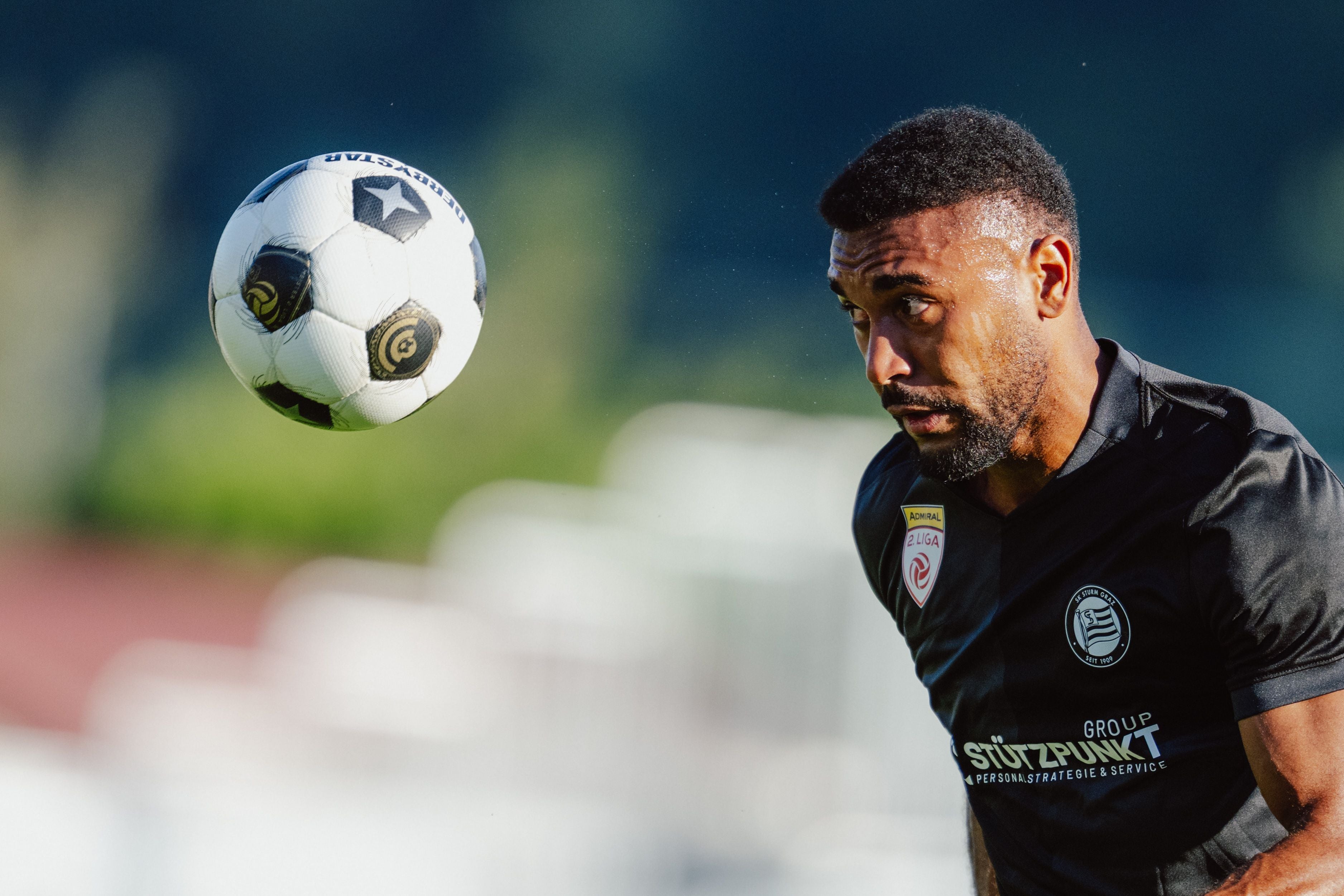 Ein Fußballspieler von Sturm Graz II konzentriert sich auf einen heranfliegenden Ball.