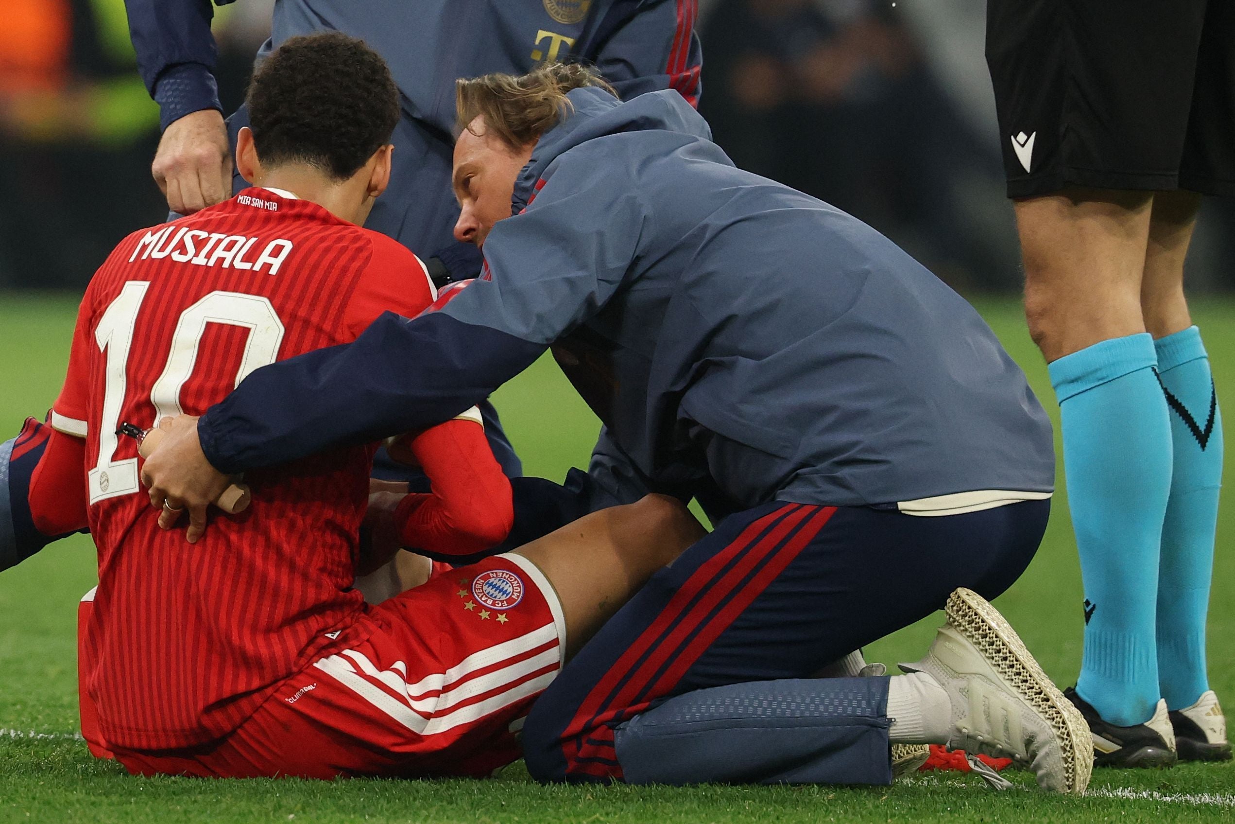 Jamal Musiala vom FC Bayern München wird während eines Spiels auf dem Spielfeld medizinisch behandelt.
