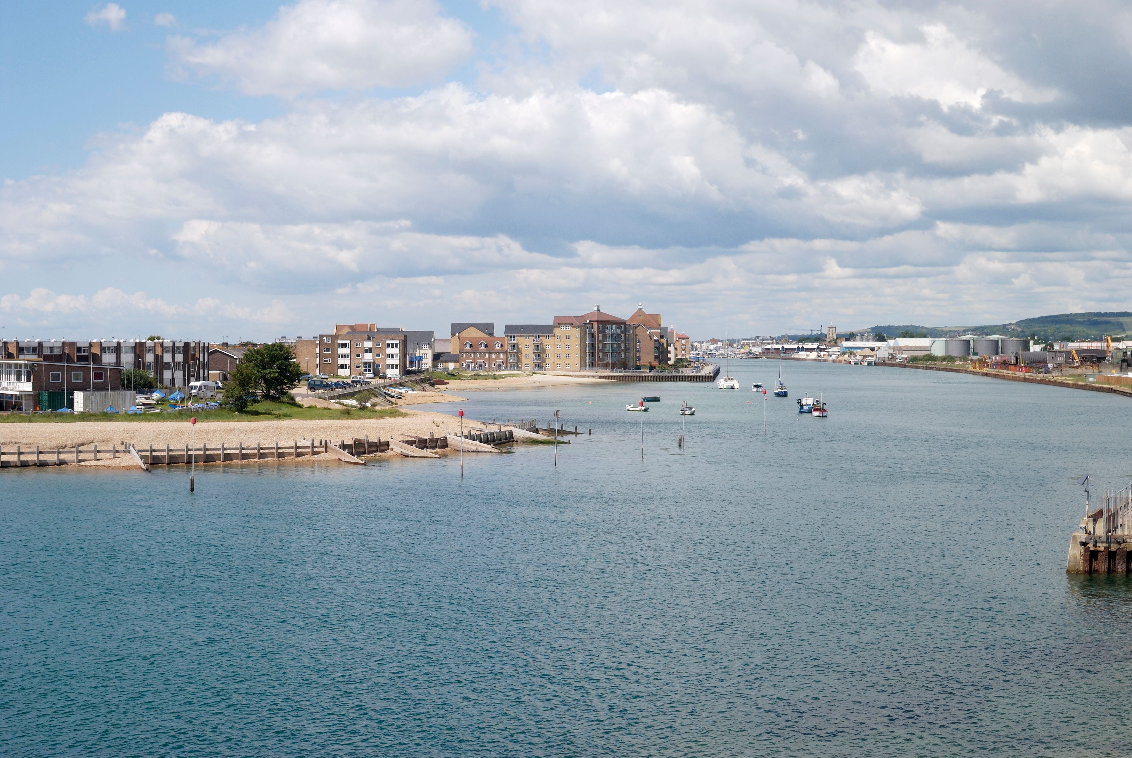 Blick auf den Shoreham Harbour und River Adur mit Wohnhäusern und Booten unter Wolken.