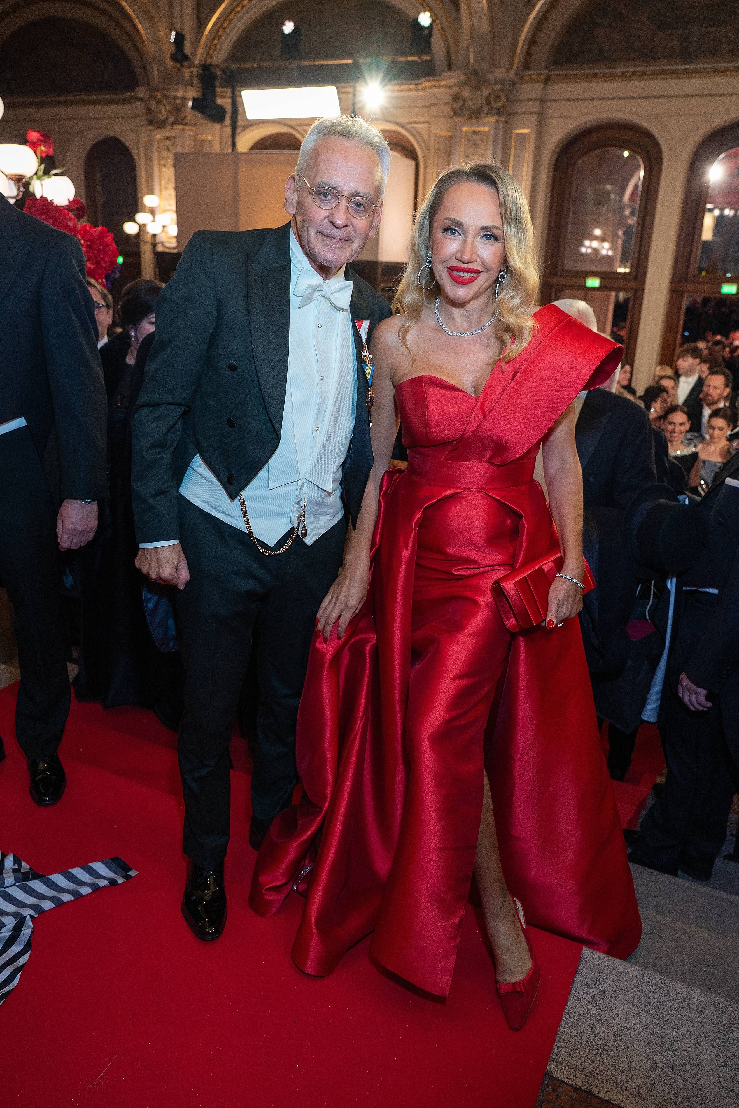 Ein elegant gekleidetes Paar auf dem roten Teppich beim Wiener Opernball in der Staatsoper.