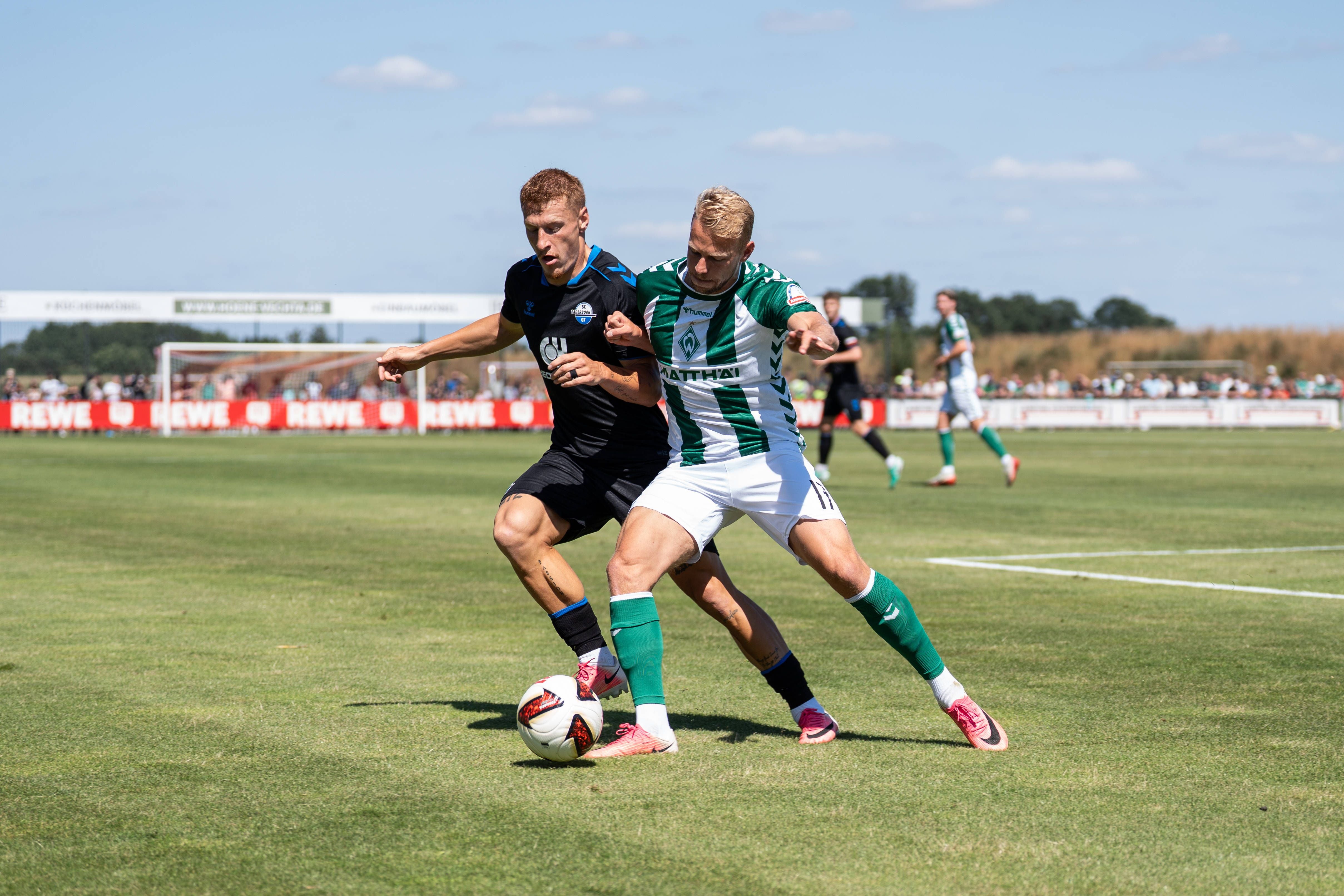 Zwei Fußballspieler kämpfen beim Testspiel Werder Bremen gegen SC Paderborn um den Ball.