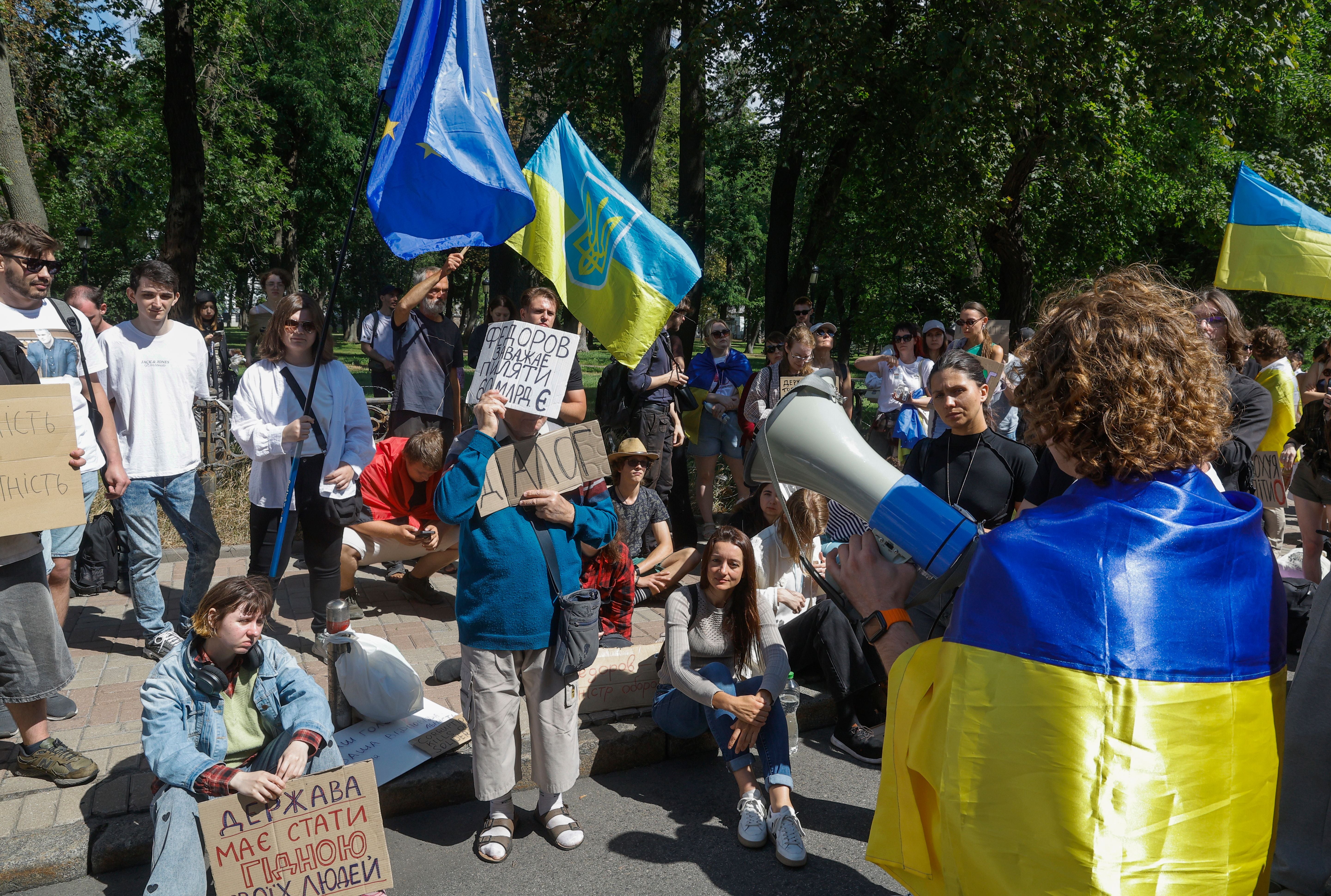 Menschen protestieren in Kiew mit Schildern und Fahnen gegen den Austausch des Verteidigungsministers.
