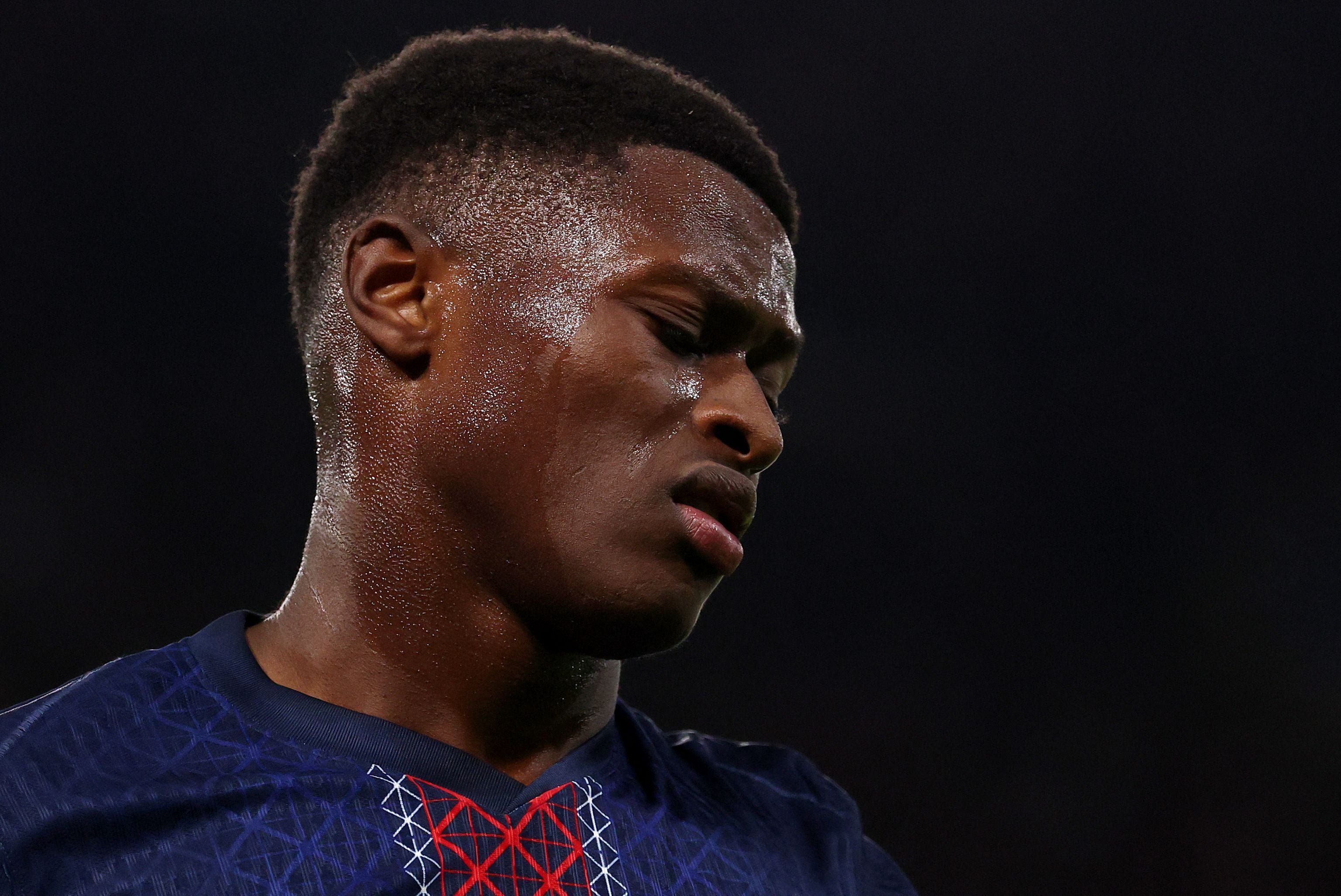 Ein Fußballspieler im PSG-Trikot schaut mit schmerzverzerrtem Gesicht zur Seite und schwitzt stark.