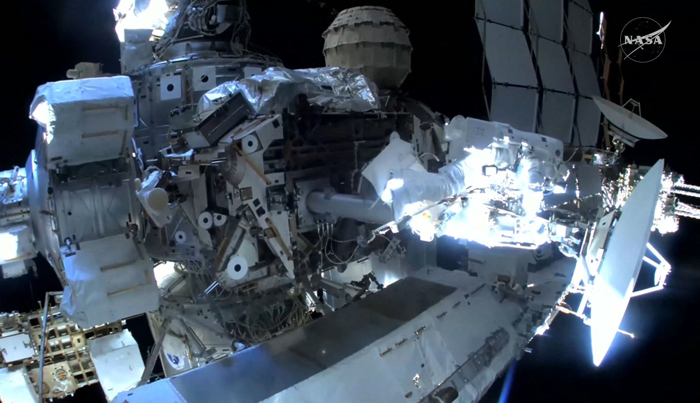 Eine Astronautin arbeitet während eines Weltraumspaziergangs an der Außenseite der ISS.