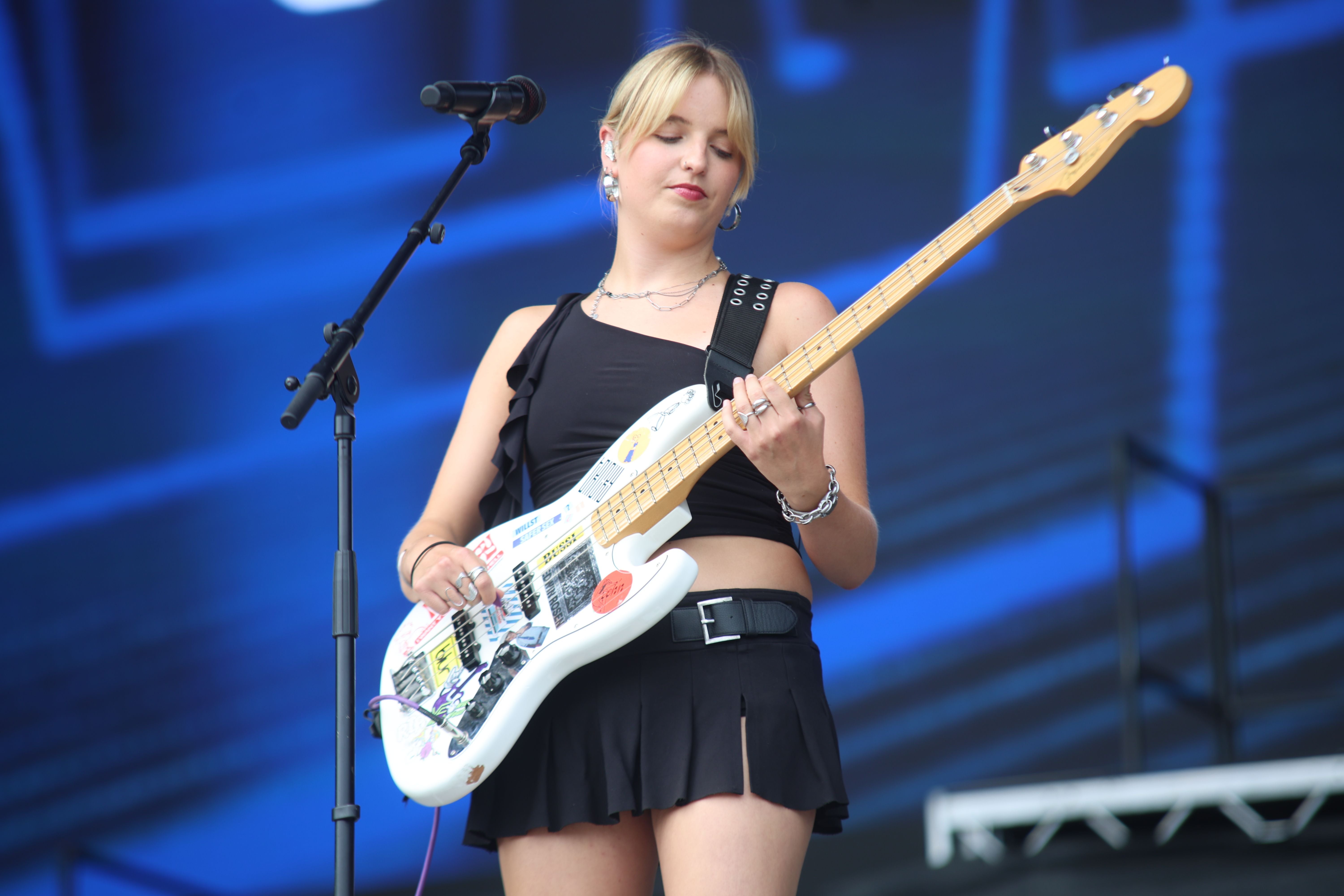 Junge Frau spielt Bassgitarre auf einer Bühne beim Frequency Festival.