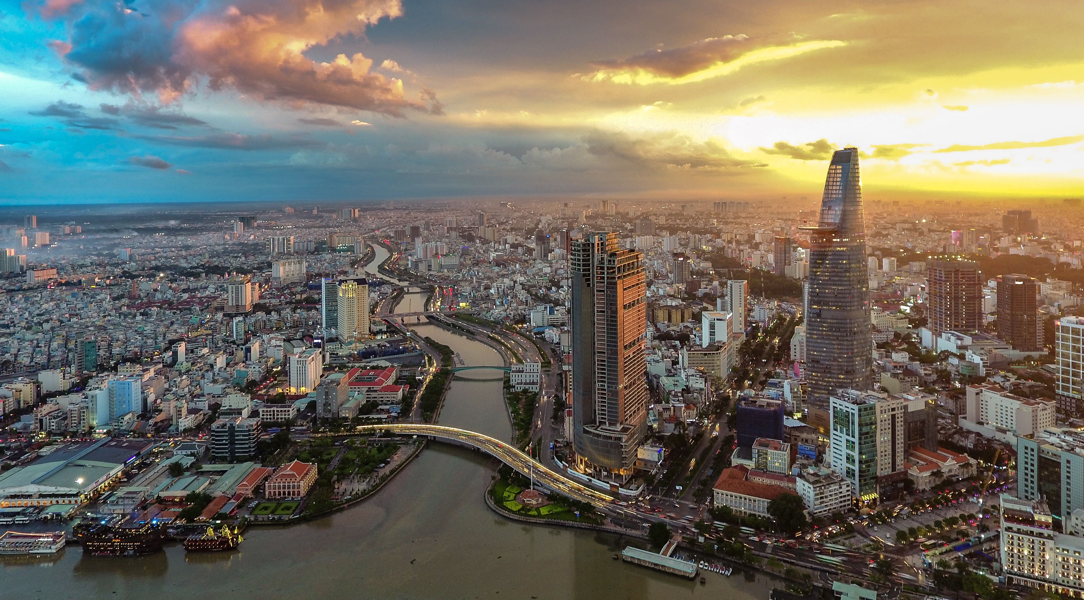 Atemberaubende Skyline von Saigon bei Sonnenuntergang mit Fluss und modernen Hochhäusern.