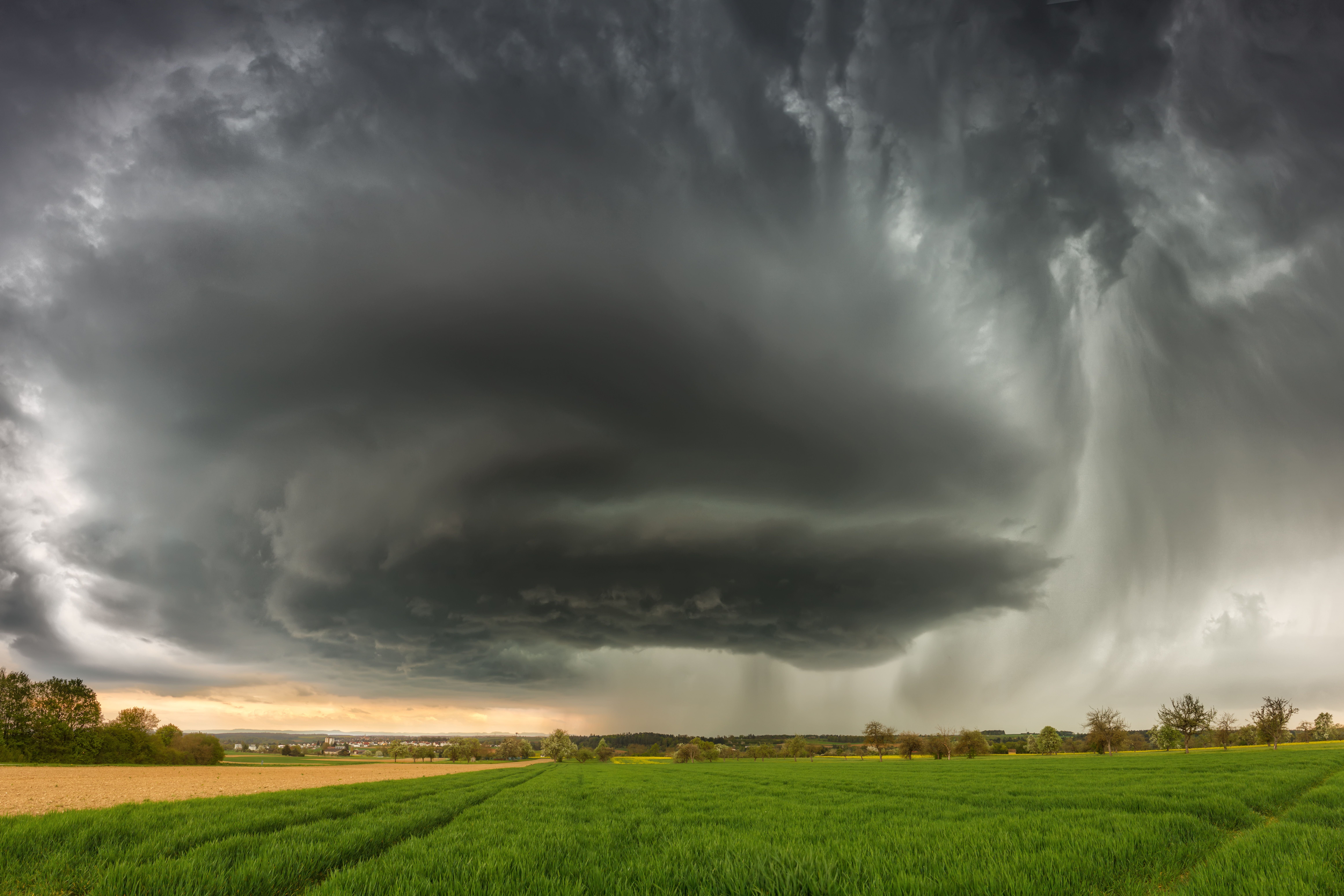Gewaltige Superzelle mit dunklen Wolken über grüner Landschaft bei Freudenstadt, Baden-Württemberg.
