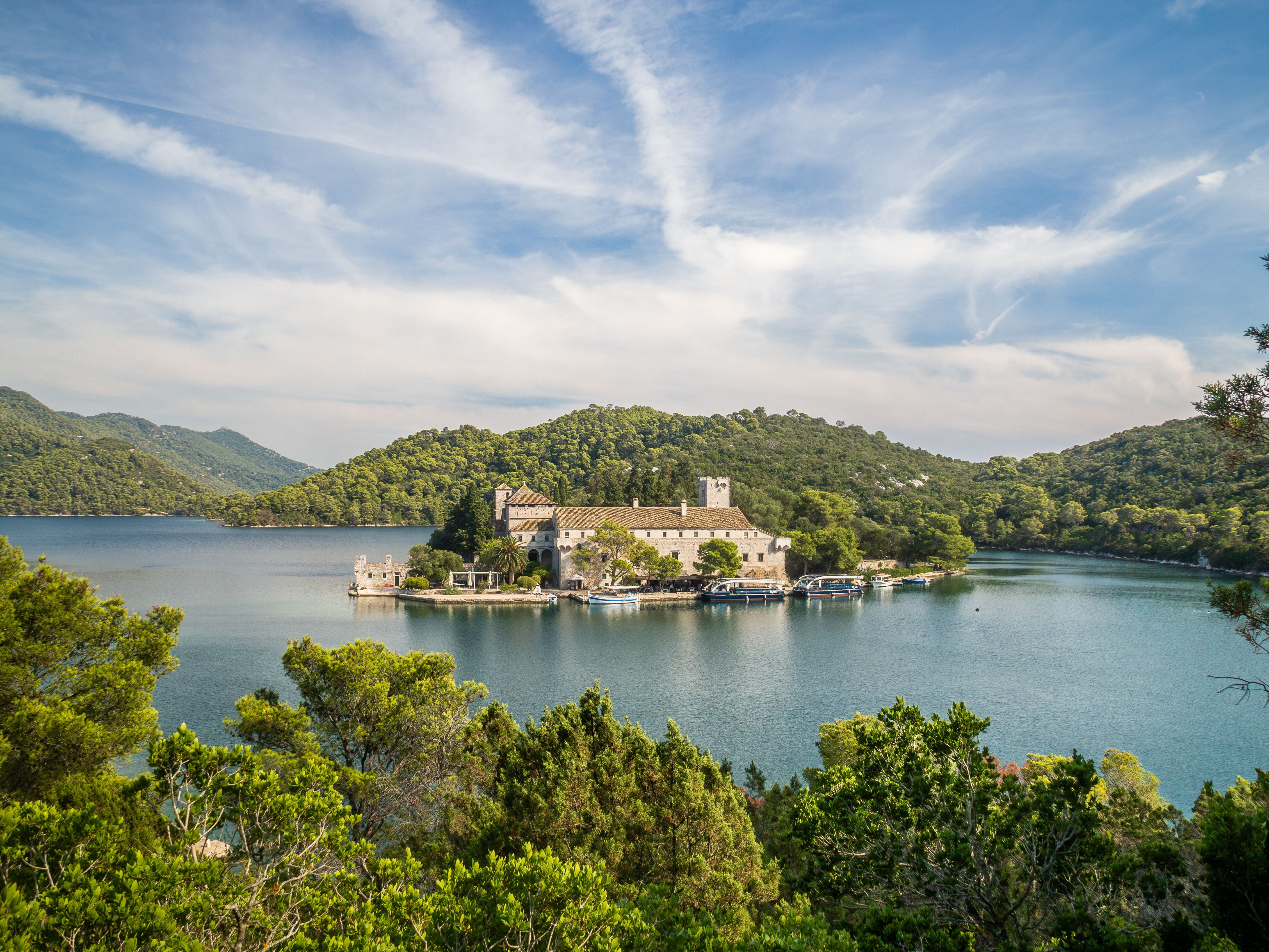 Benediktinerkloster auf der Insel St. Maria im Veliko Jezero, umgeben von bewaldeten Hügeln.