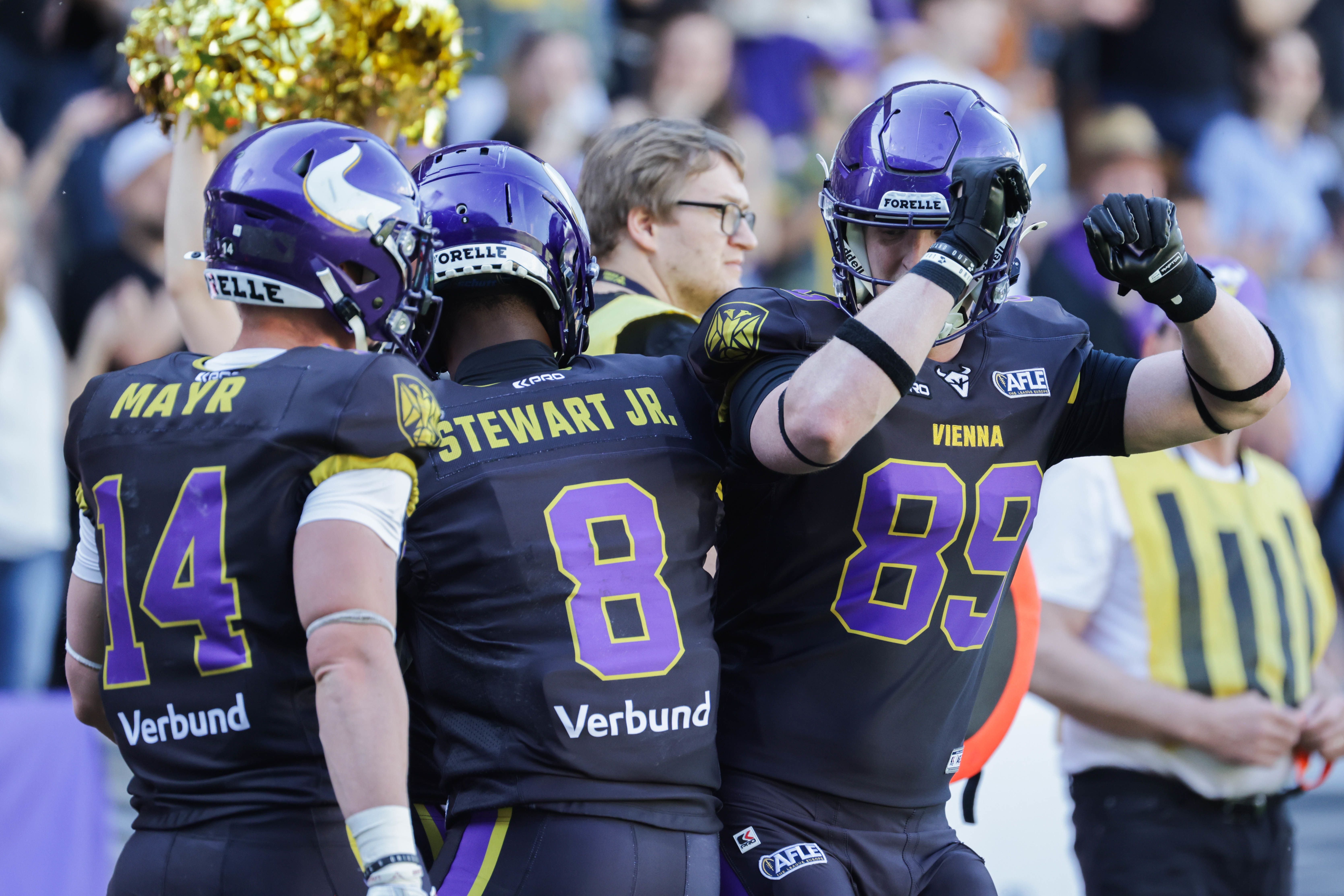 Drei Vienna Vikings Footballspieler feiern während eines Spiels auf dem Feld.