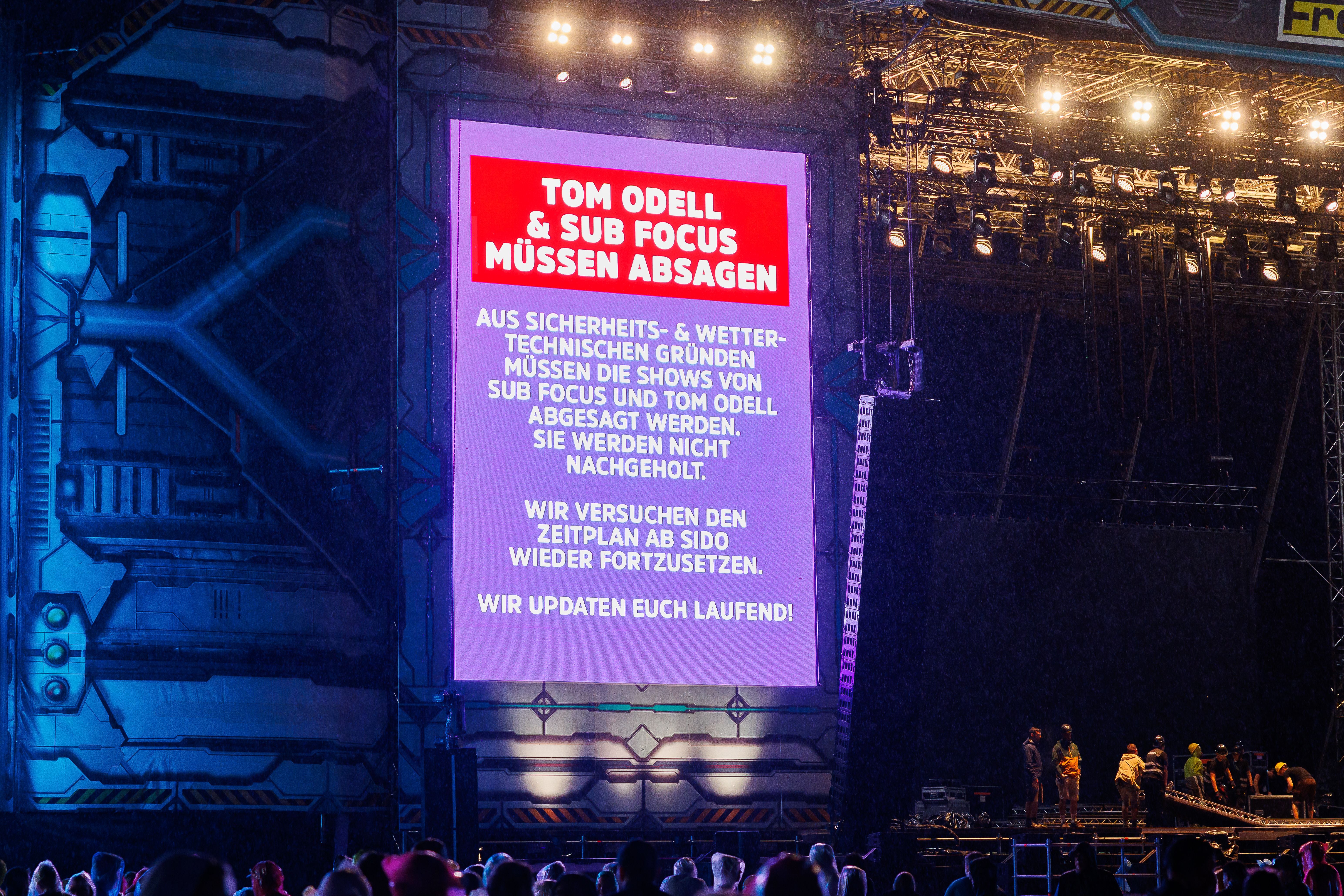 Eine große Leinwand informiert auf einem Festival über die Absage von Konzerten wegen Sturm.