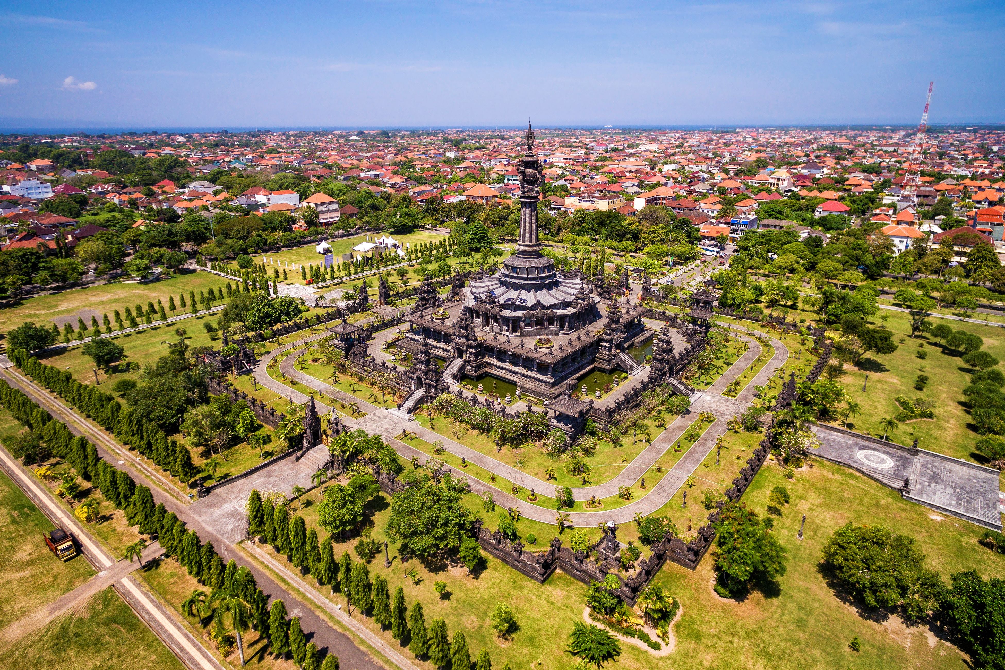 Luftaufnahme des Bajra Sandhi Monuments in Denpasar, Bali, umgeben von Parkanlagen und Stadt.