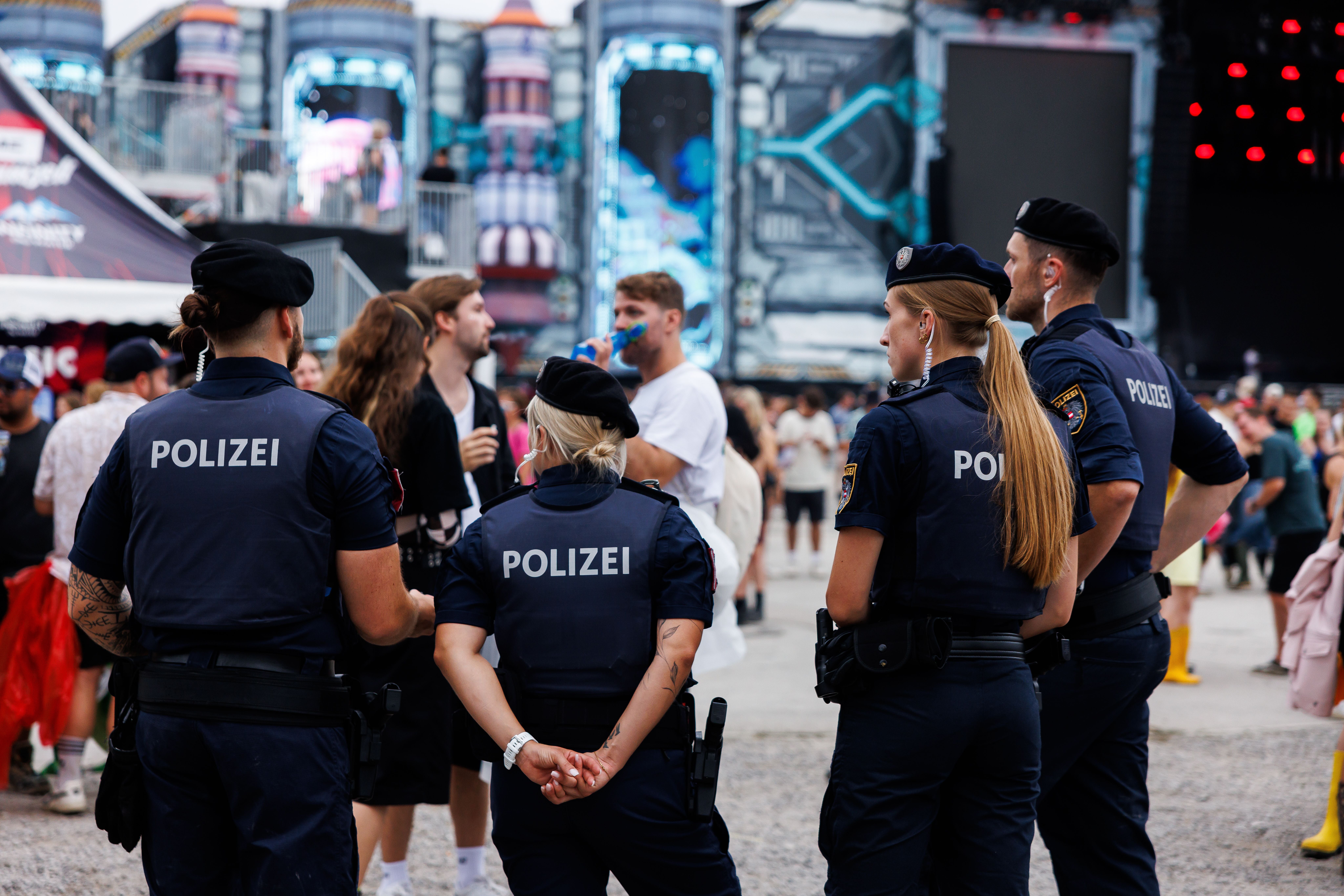 Vier Polizisten stehen auf einem Festivalgelände vor der Space Stage beim Frequency Festival 2026.
