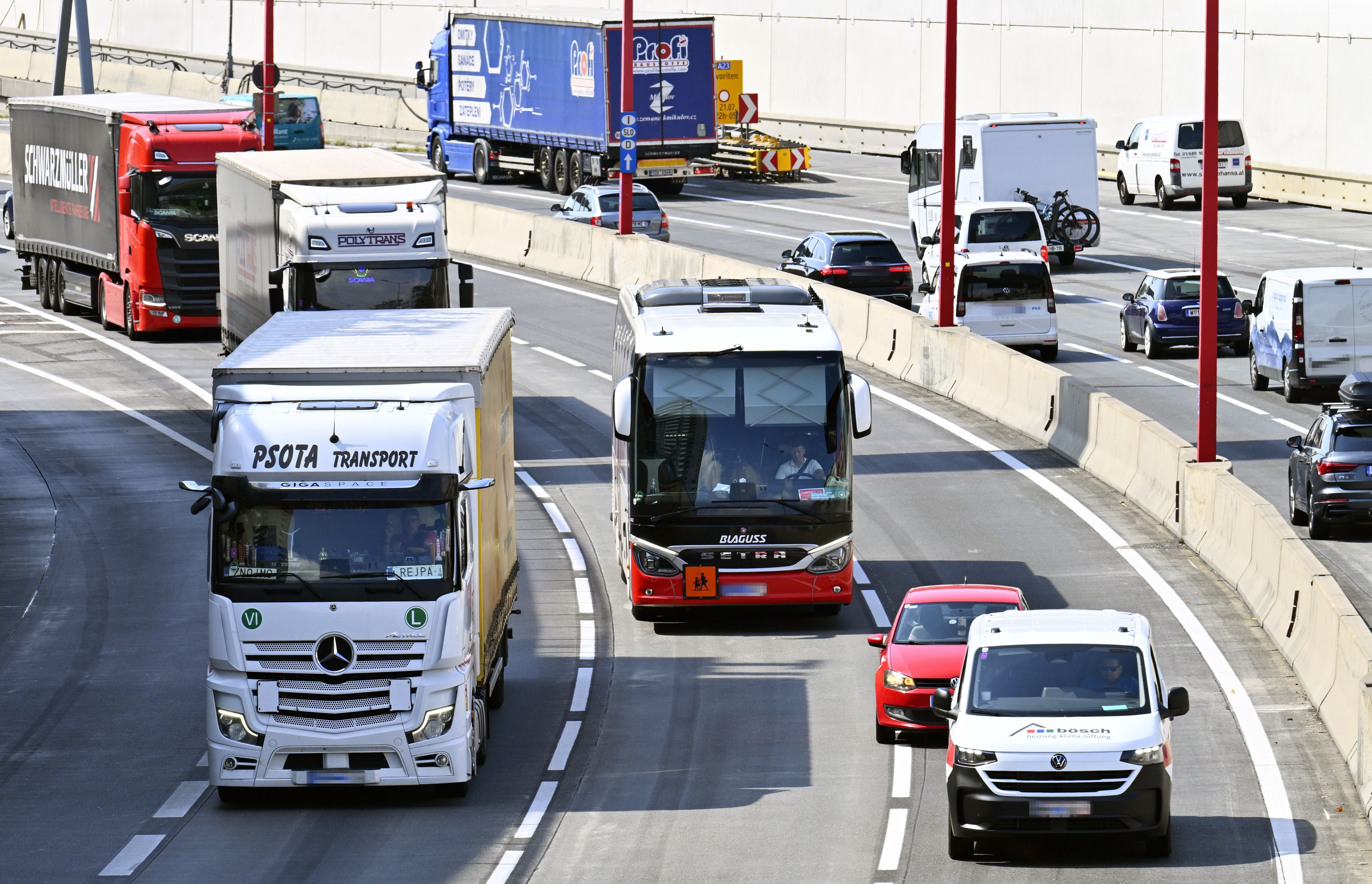 Mehrere Lkw, Autos und ein Bus fahren auf der Wiener Tangente in beide Richtungen.