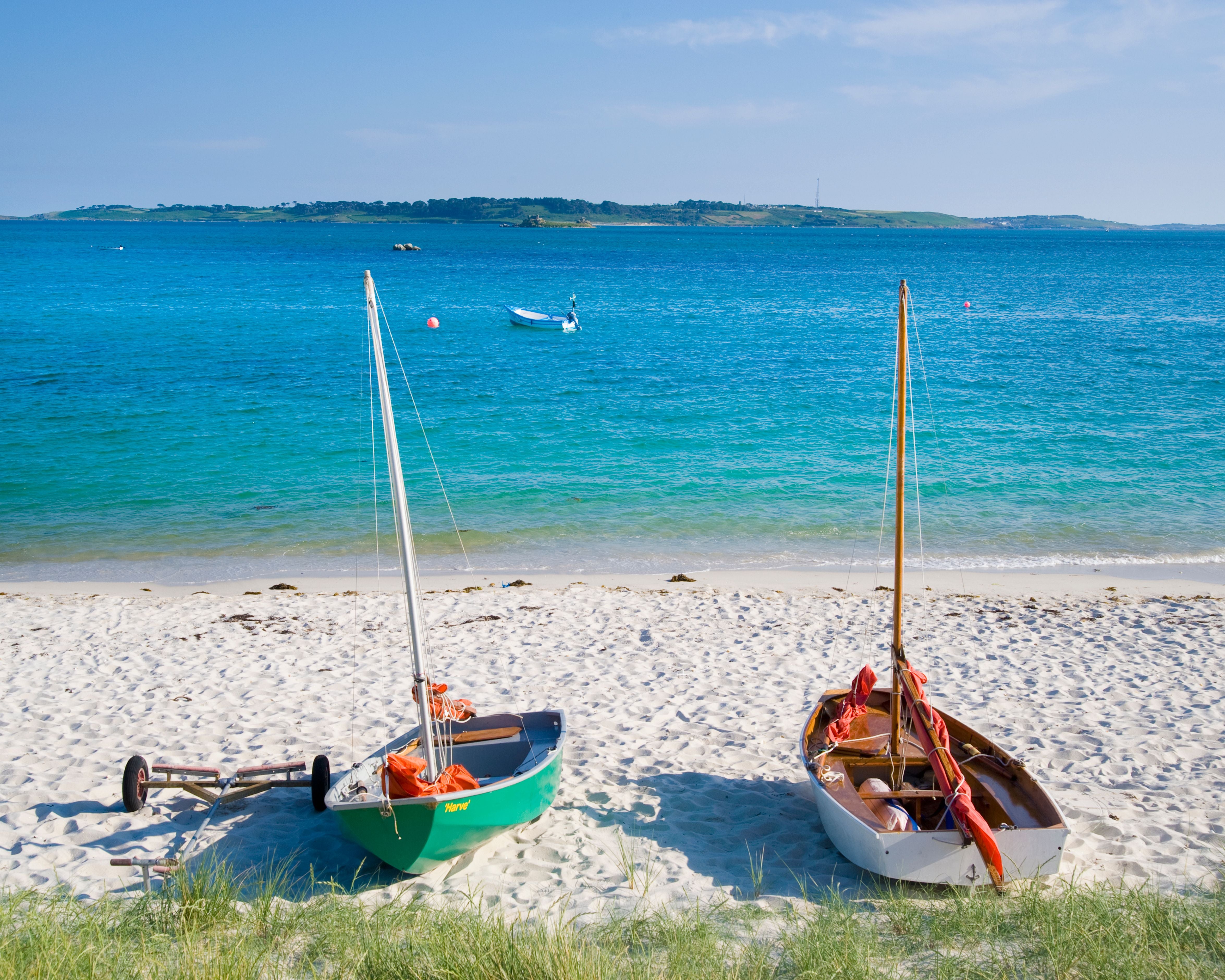 Zwei kleine Segelboote stehen am Sandstrand vor türkisblauem Meer auf St. Martins Beach.