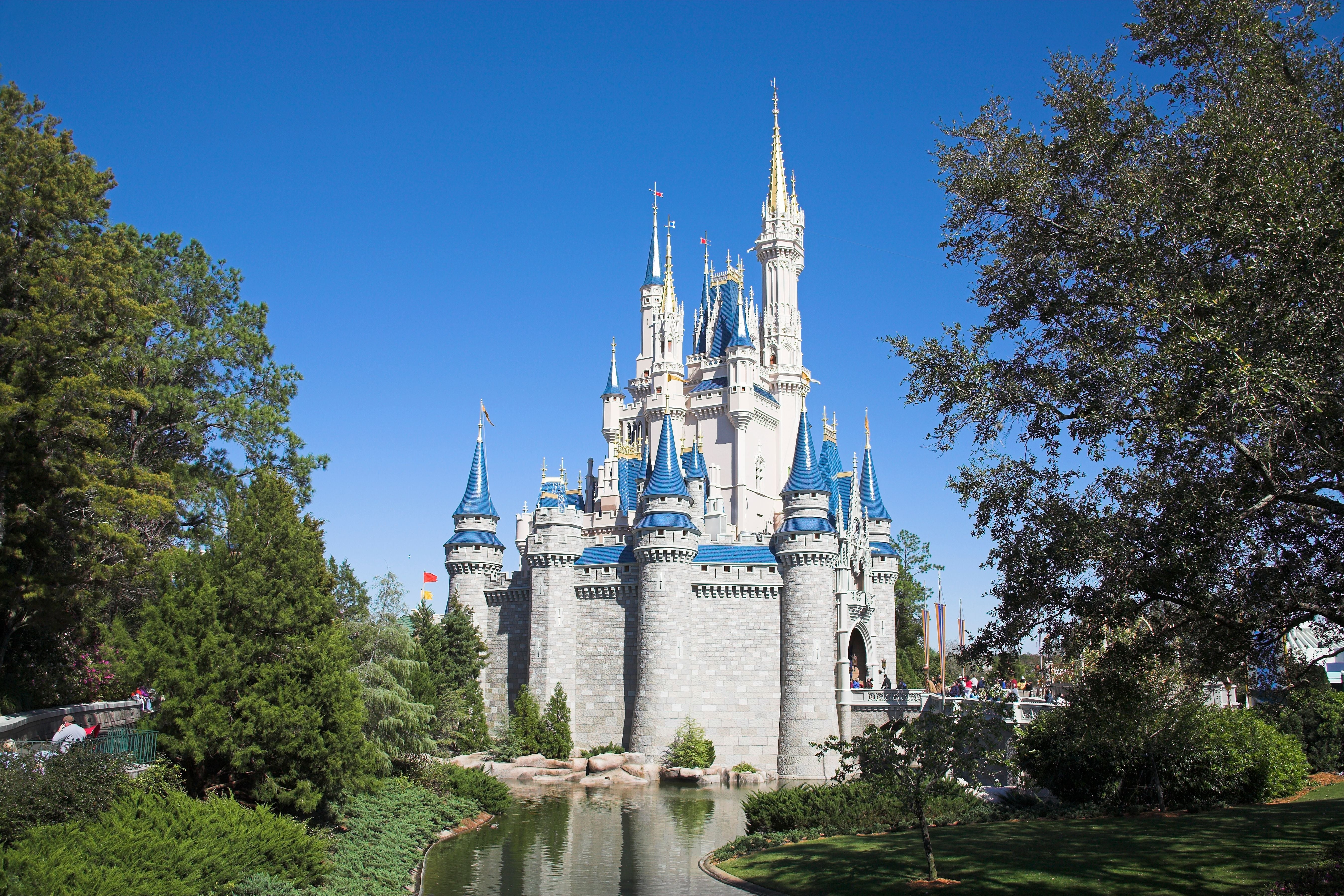 Das Cinderella-Schloss im Magic Kingdom bei strahlend blauem Himmel und grüner Umgebung.