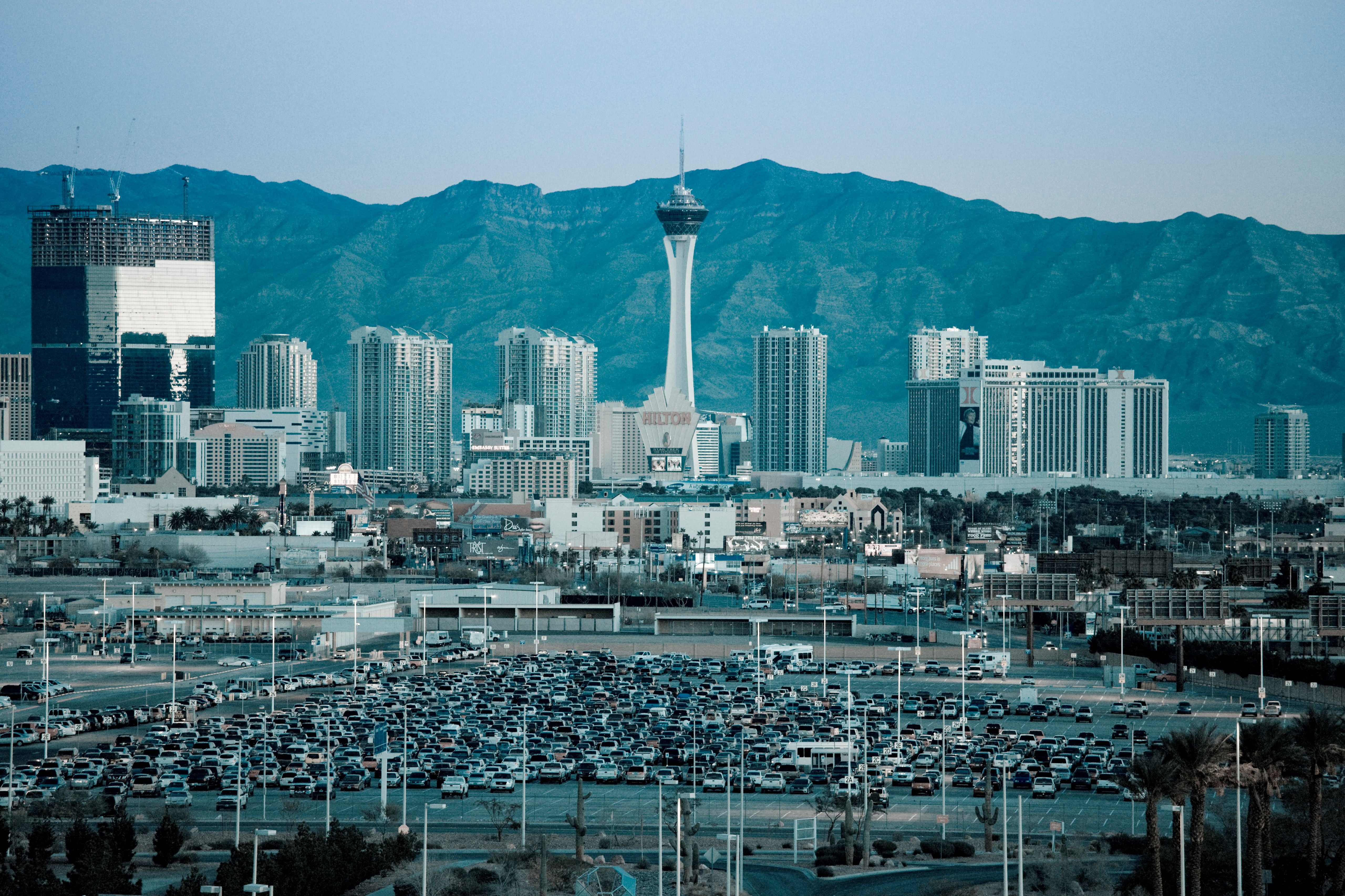 Blick auf die Skyline von Las Vegas mit vielen Autos auf einem Parkplatz im Vordergrund.