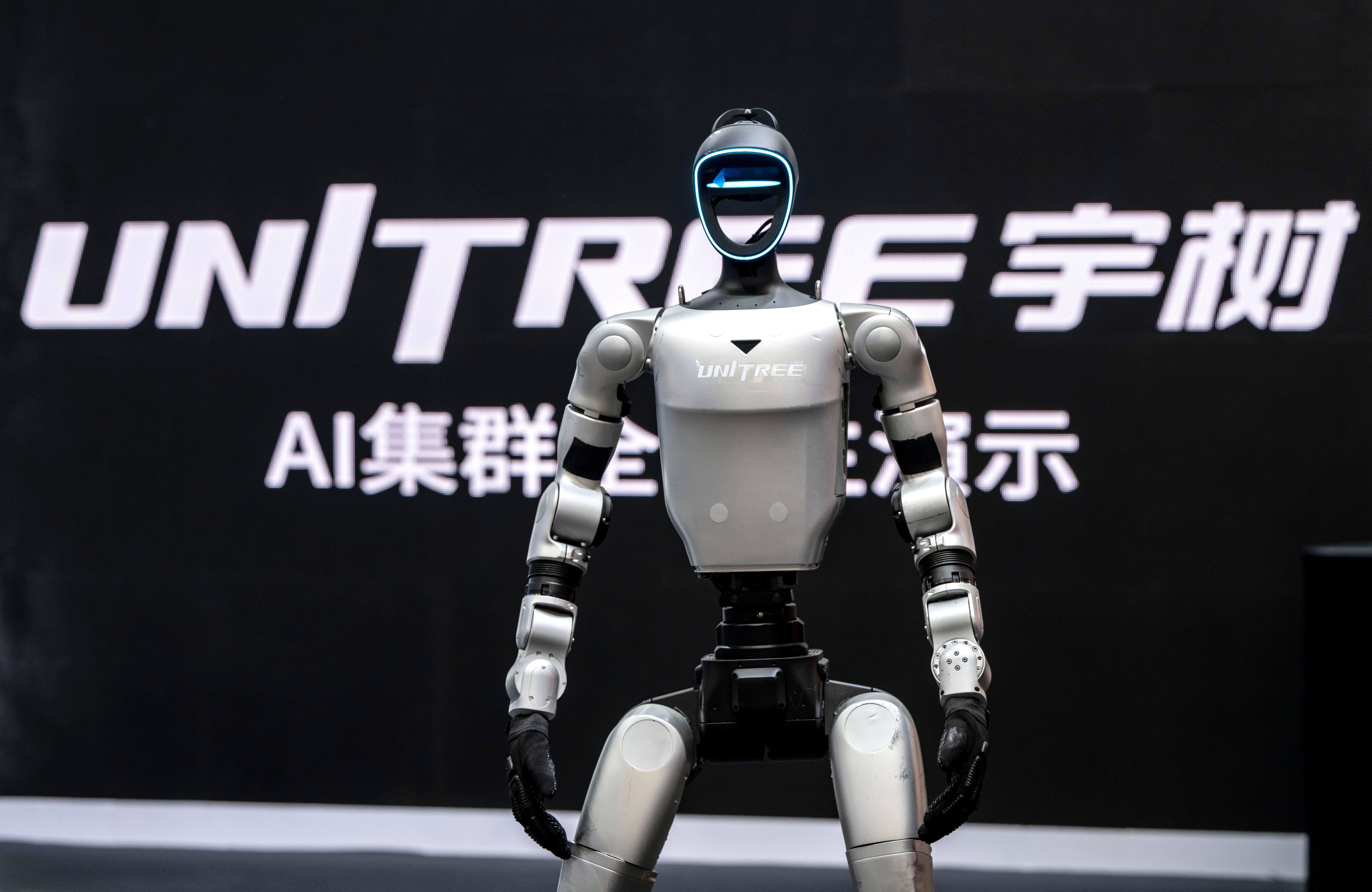 Ein humanoider Roboter von Unitree steht vor einem schwarzen Hintergrund mit Firmenlogo und Schrift.