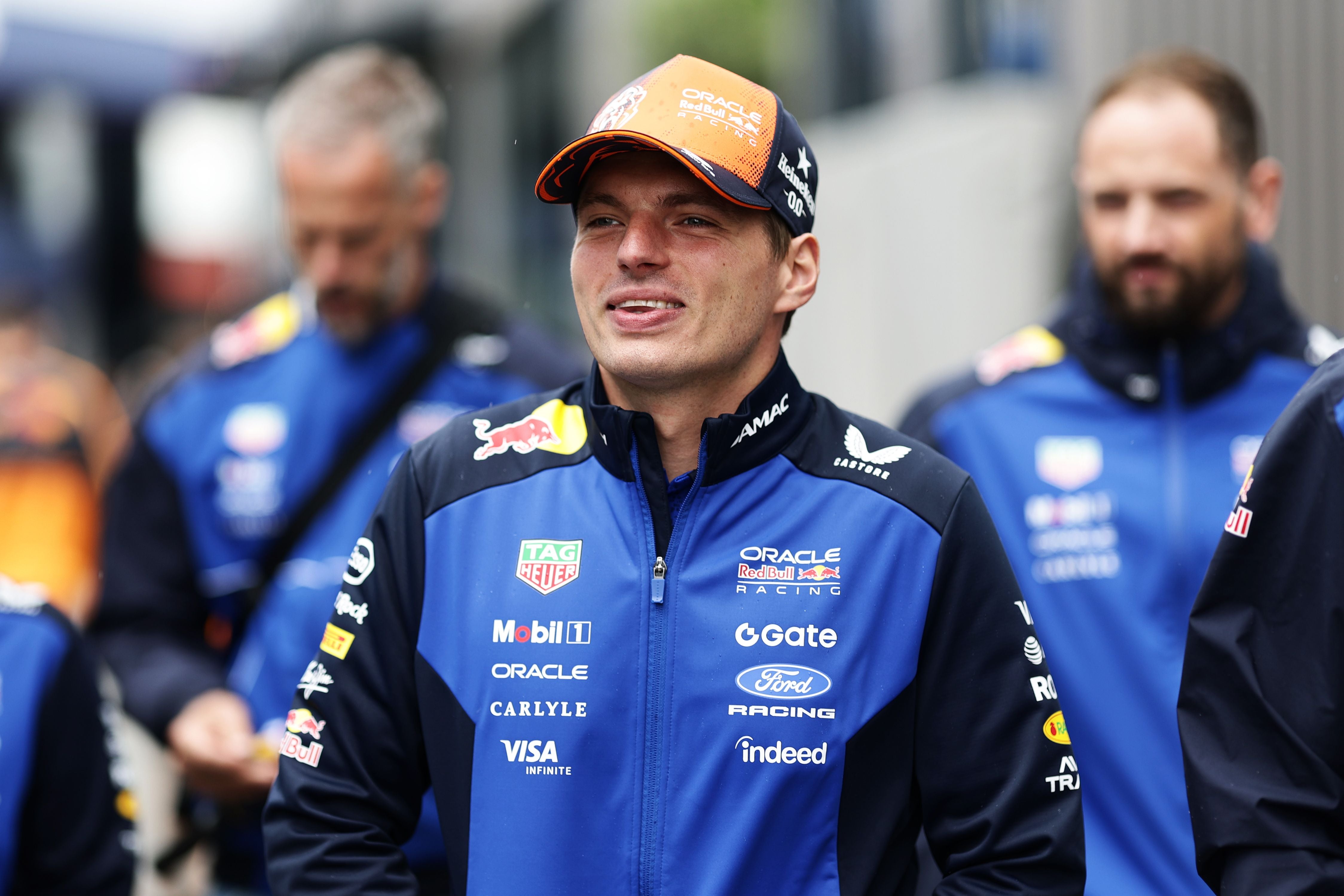 Ein Mann in Red Bull Racing Teamkleidung spaziert mit anderen Teammitgliedern im Fahrerlager.