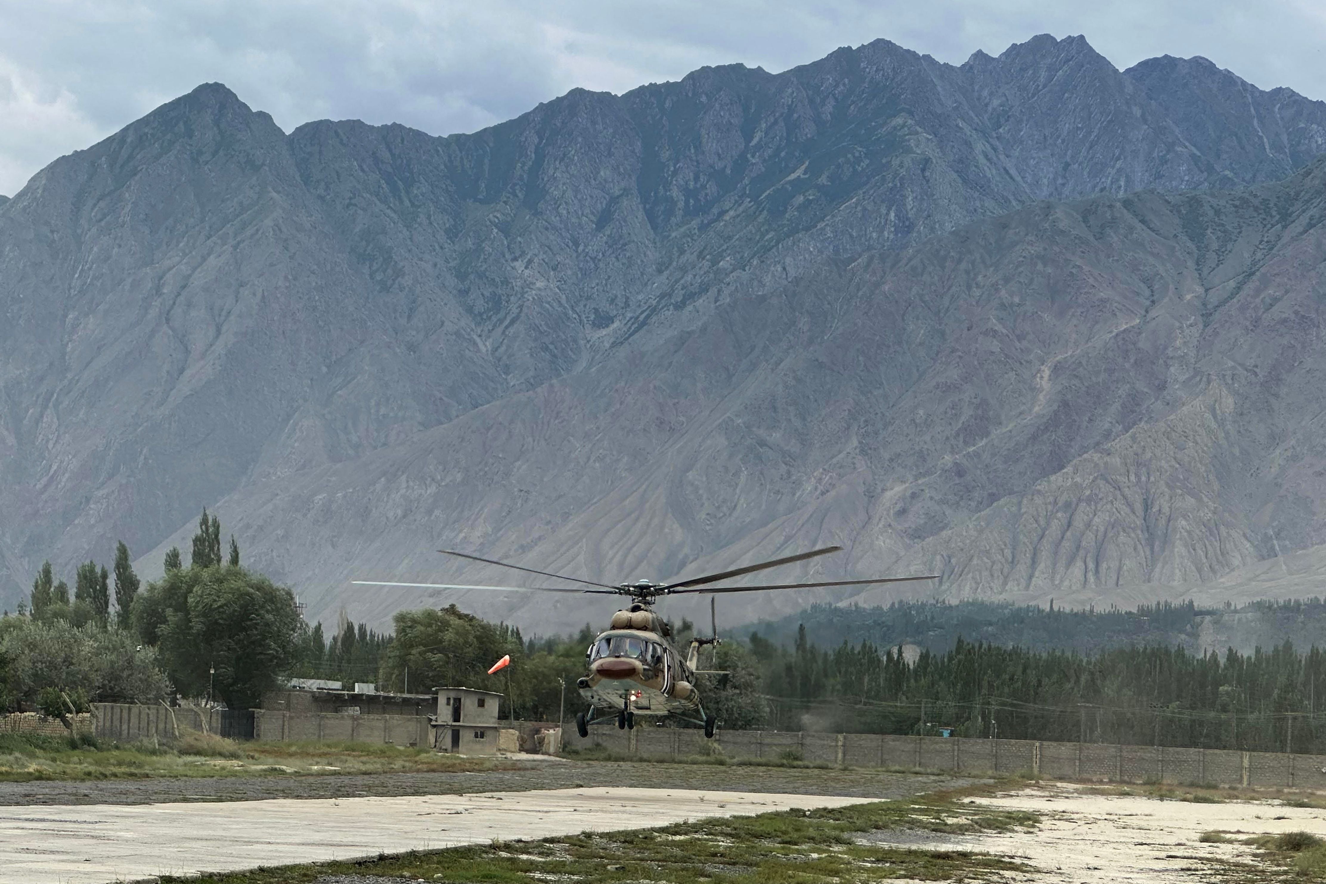 Ein pakistanischer Armeehubschrauber landet vor einer Bergkulisse auf einem Militärstützpunkt.
