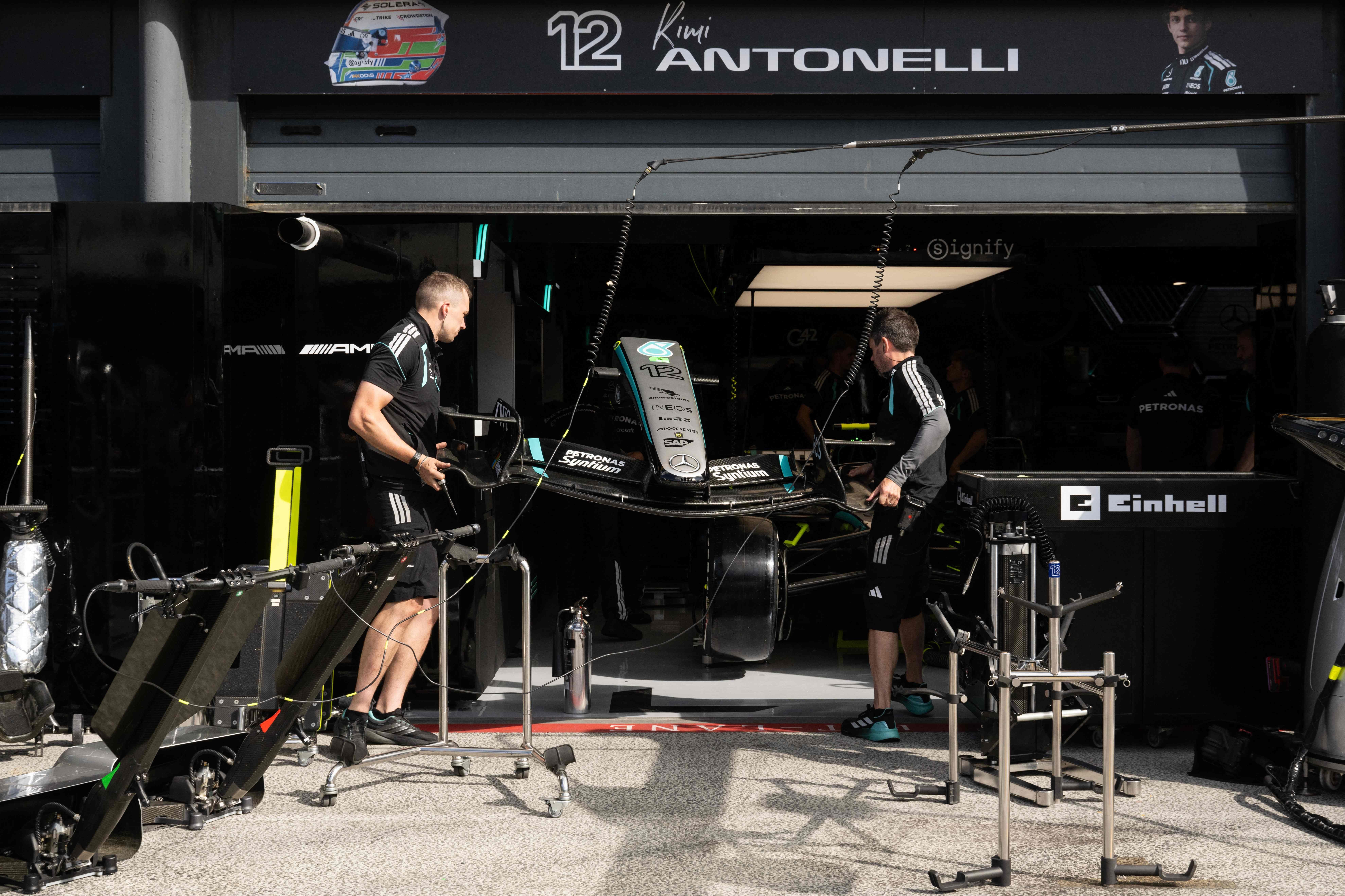 Zwei Ingenieure arbeiten vor einer Mercedes-Garage an einem Formel-1-Wagen in Zandvoort.