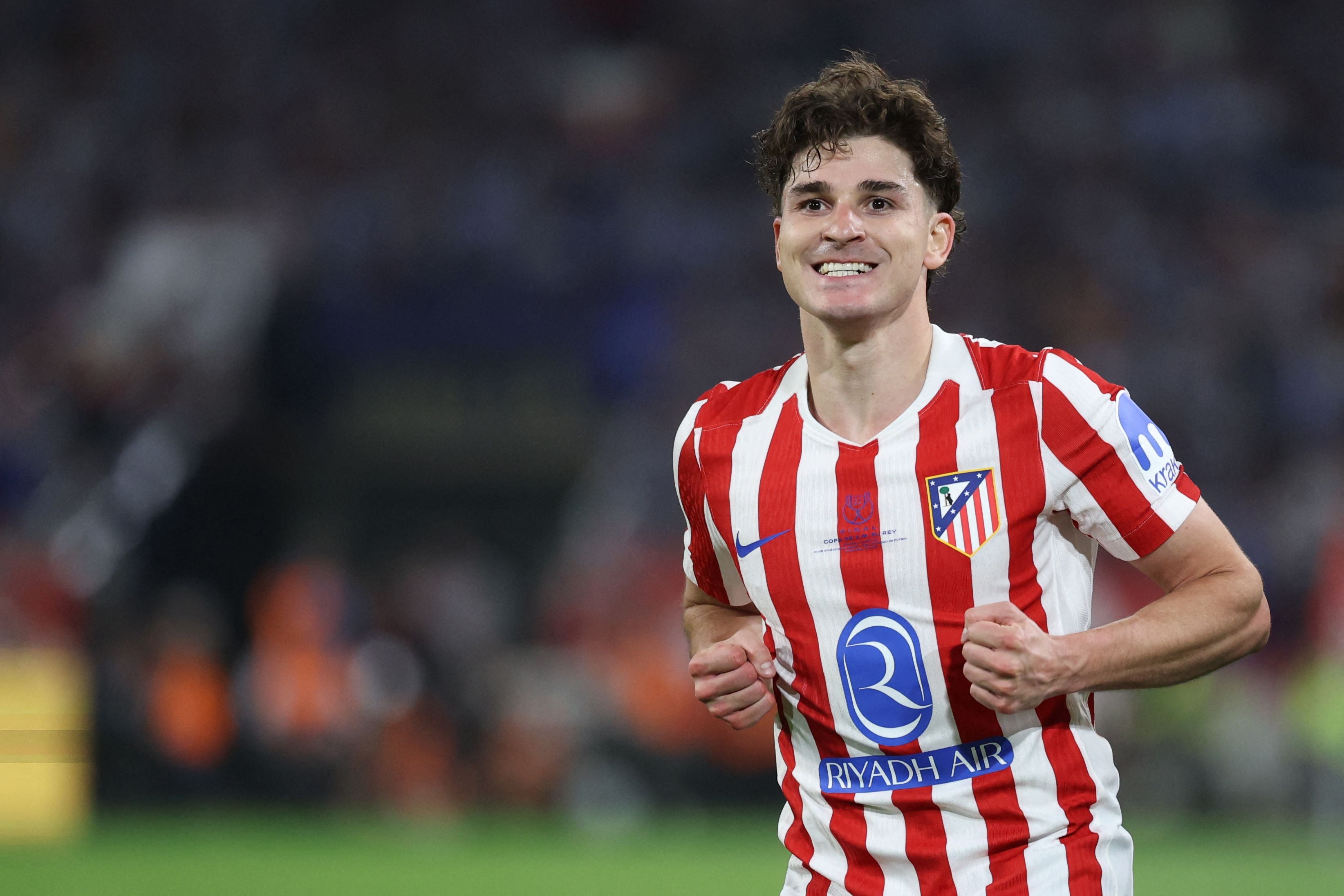 Ein Fußballspieler von Atletico Madrid jubelt im rot-weiß gestreiften Trikot auf dem Spielfeld.