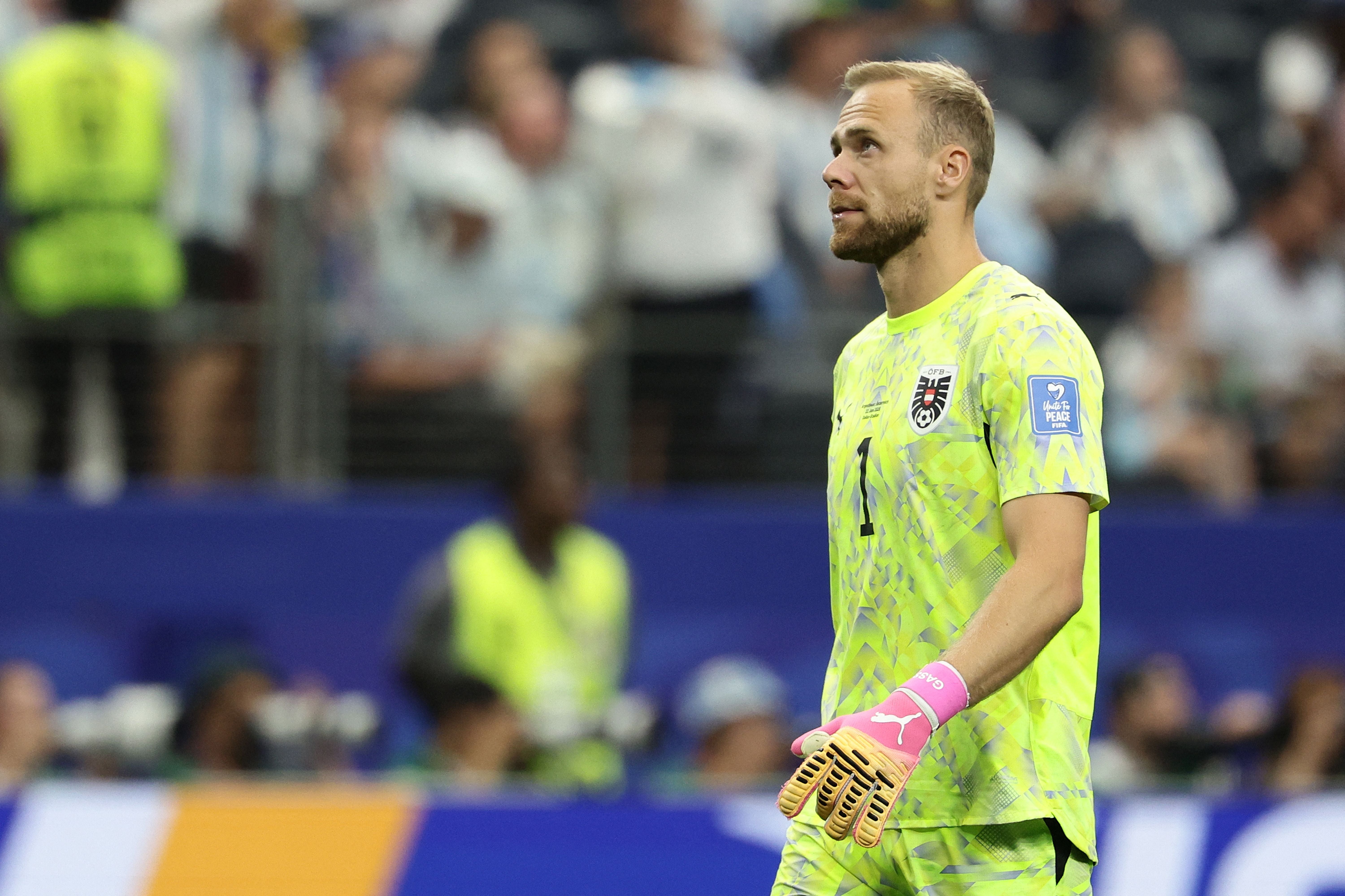 Der österreichische Torwart im gelben Trikot blickt nachdenklich während eines Spiels im Stadion.