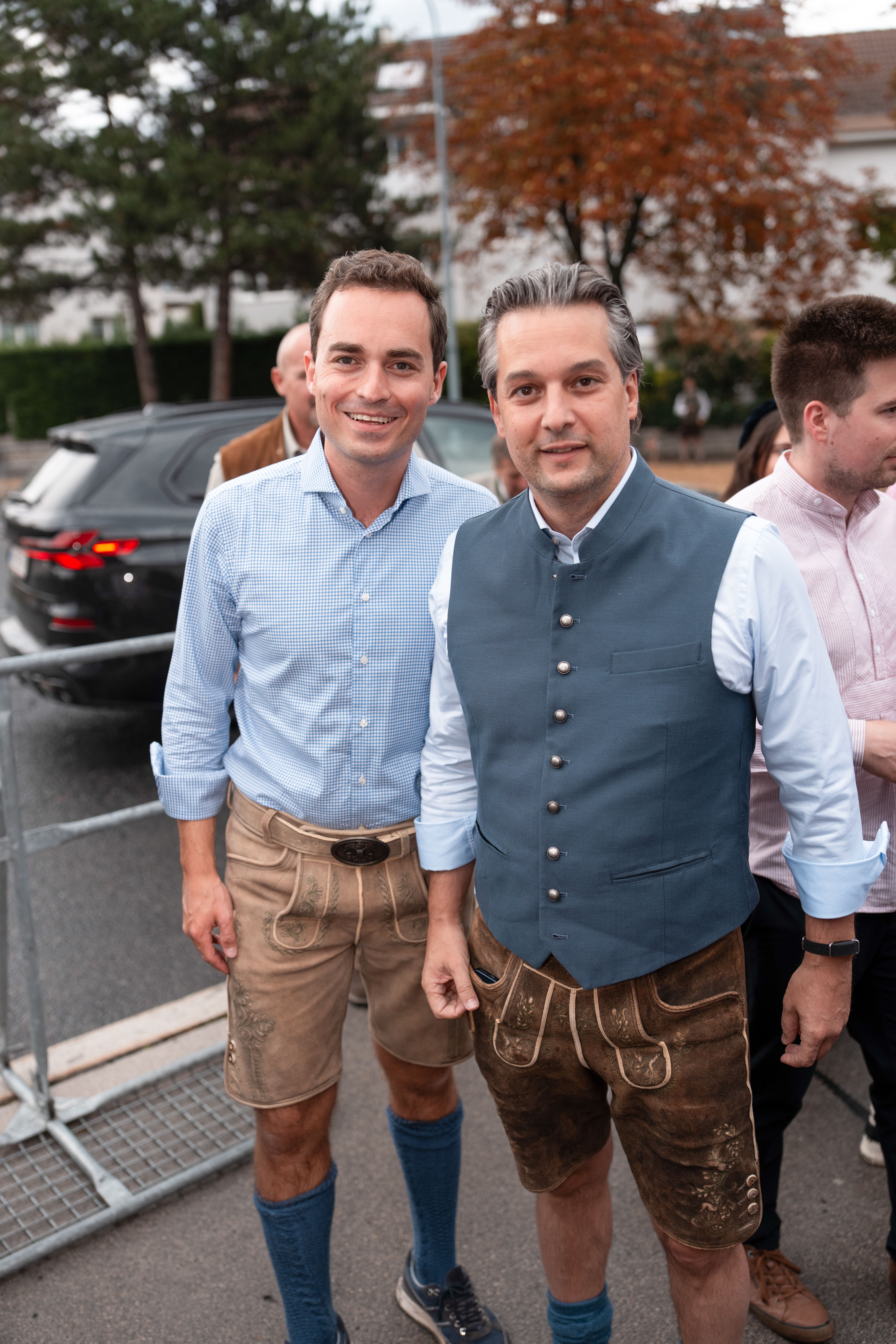 Zwei Männer in Tracht beim Neustifter Kirtag stehen nebeneinander und lächeln in die Kamera.
