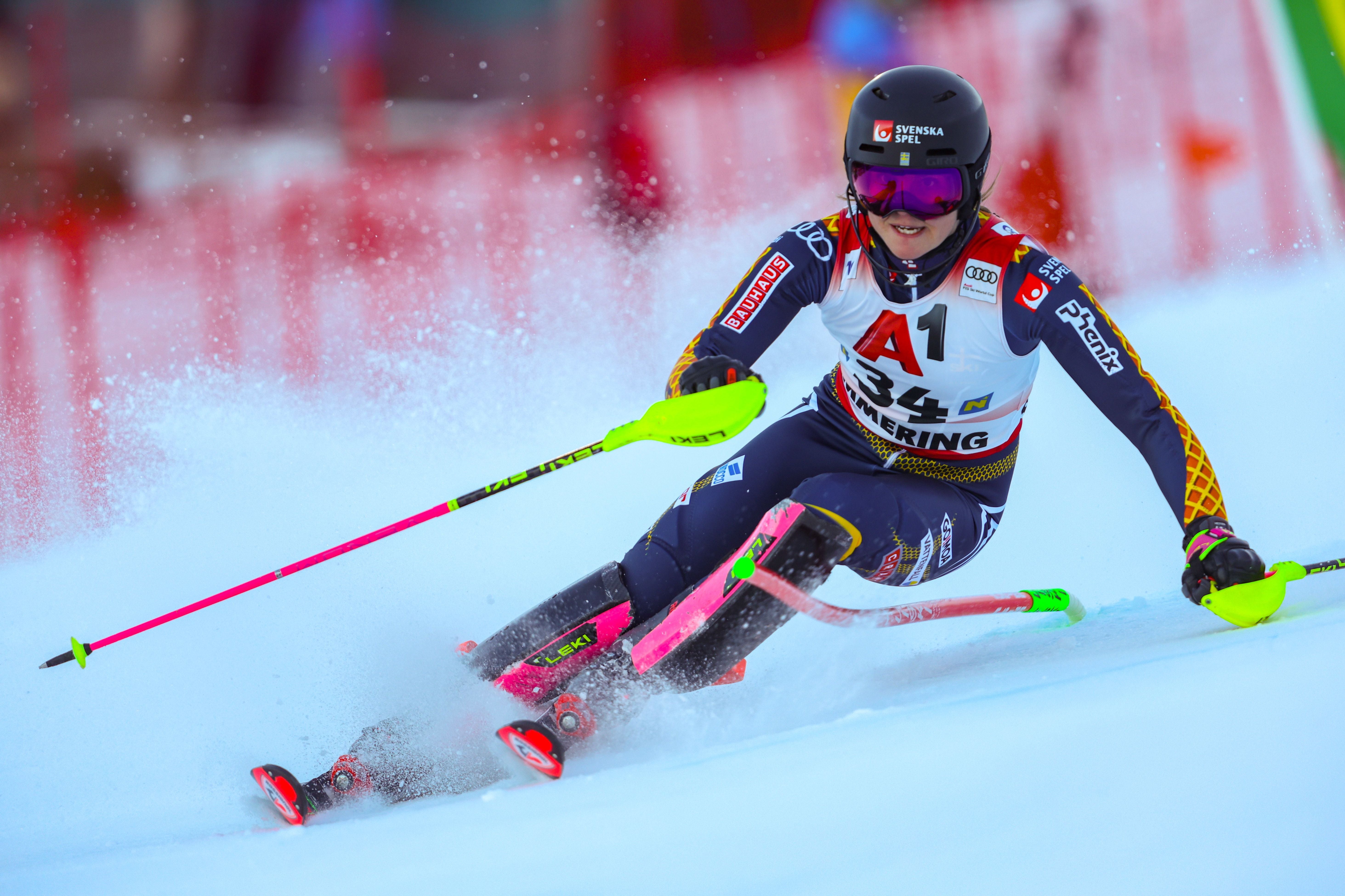 Skirennläuferin fährt Slalom bei einem Weltcup-Rennen im Schnee, Stangenabweiser sichtbar.