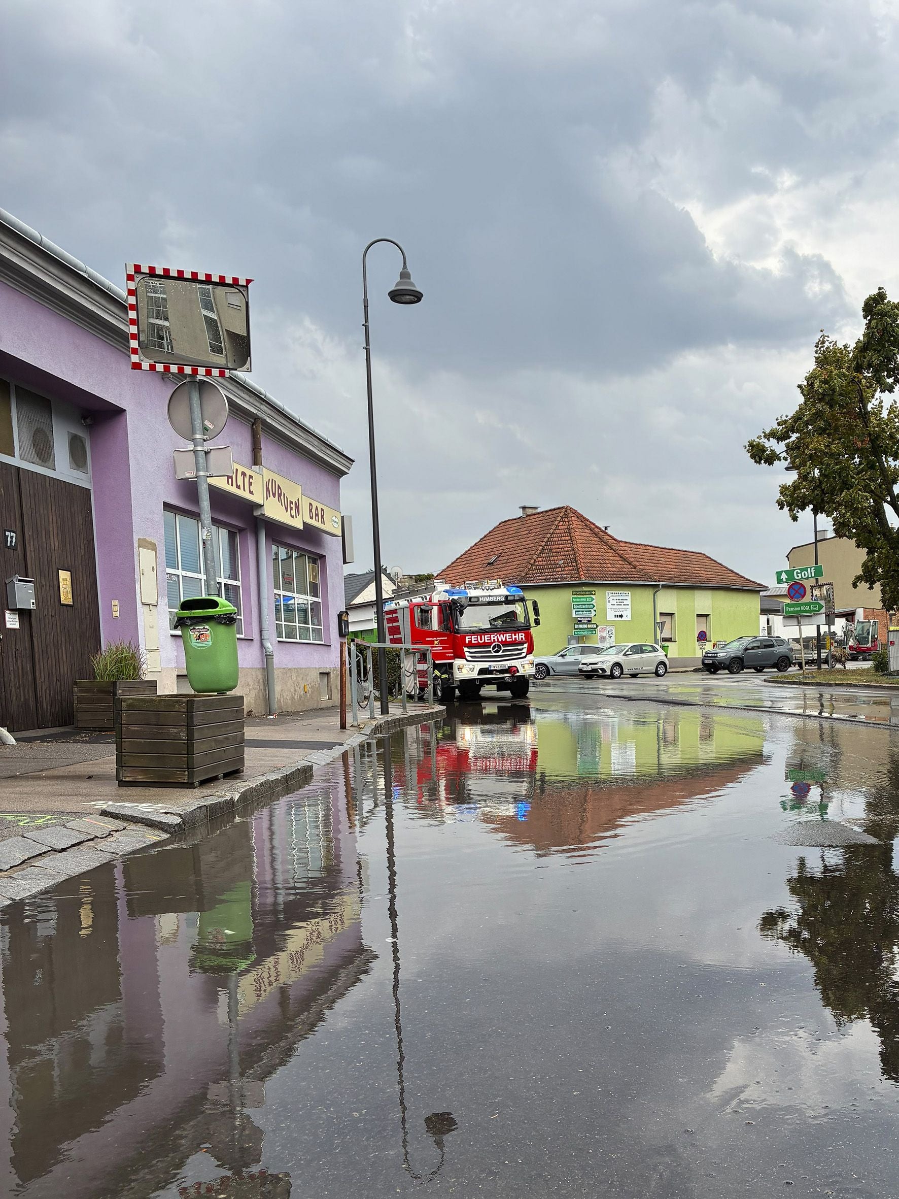 Ein Feuerwehrwagen steht nach einem Unwetter an einer überfluteten Straße in Bruck an der Leitha.