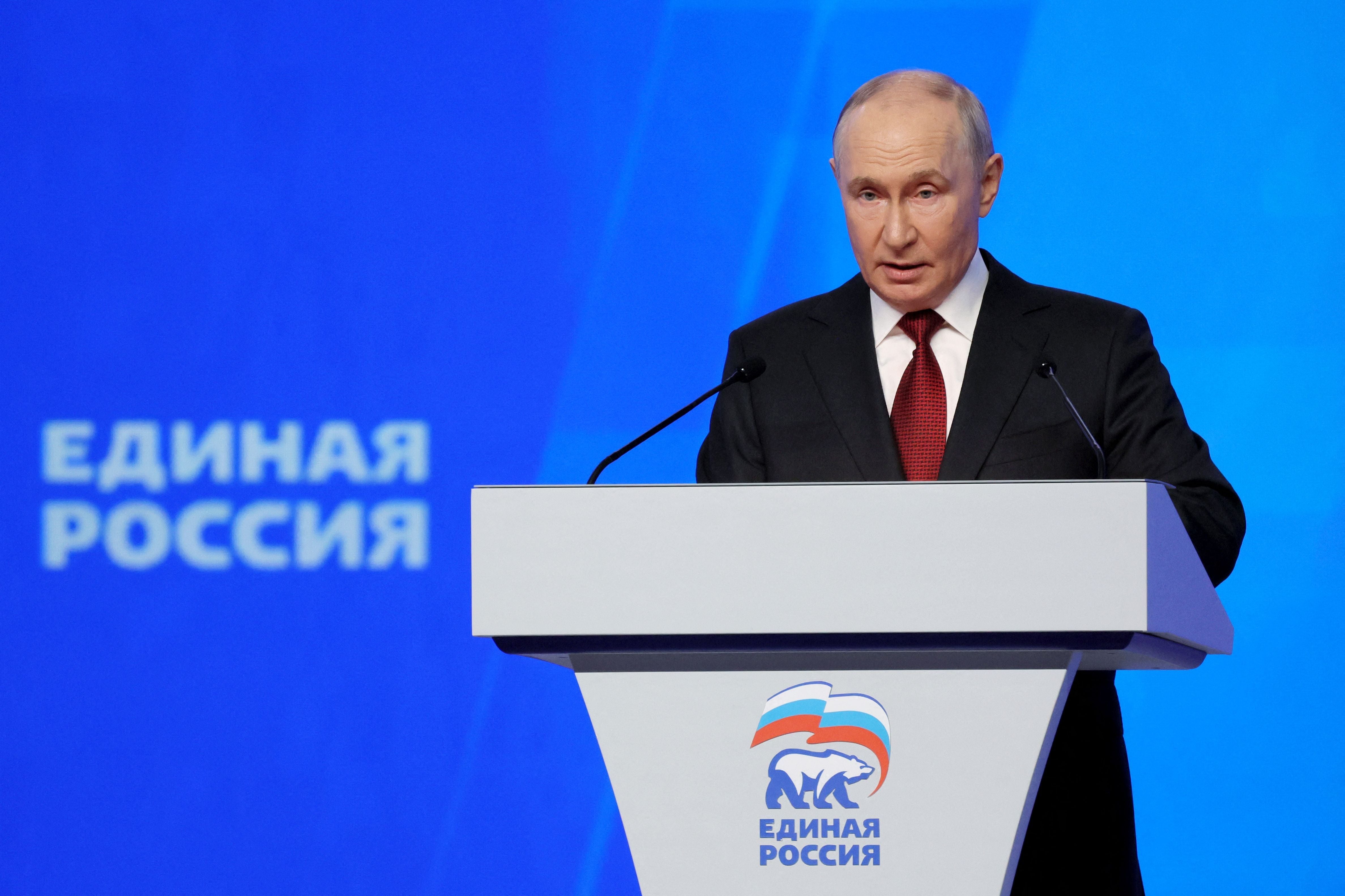 Ein Mann im Anzug spricht am Rednerpult bei einem Kongress der Partei „Einiges Russland“.