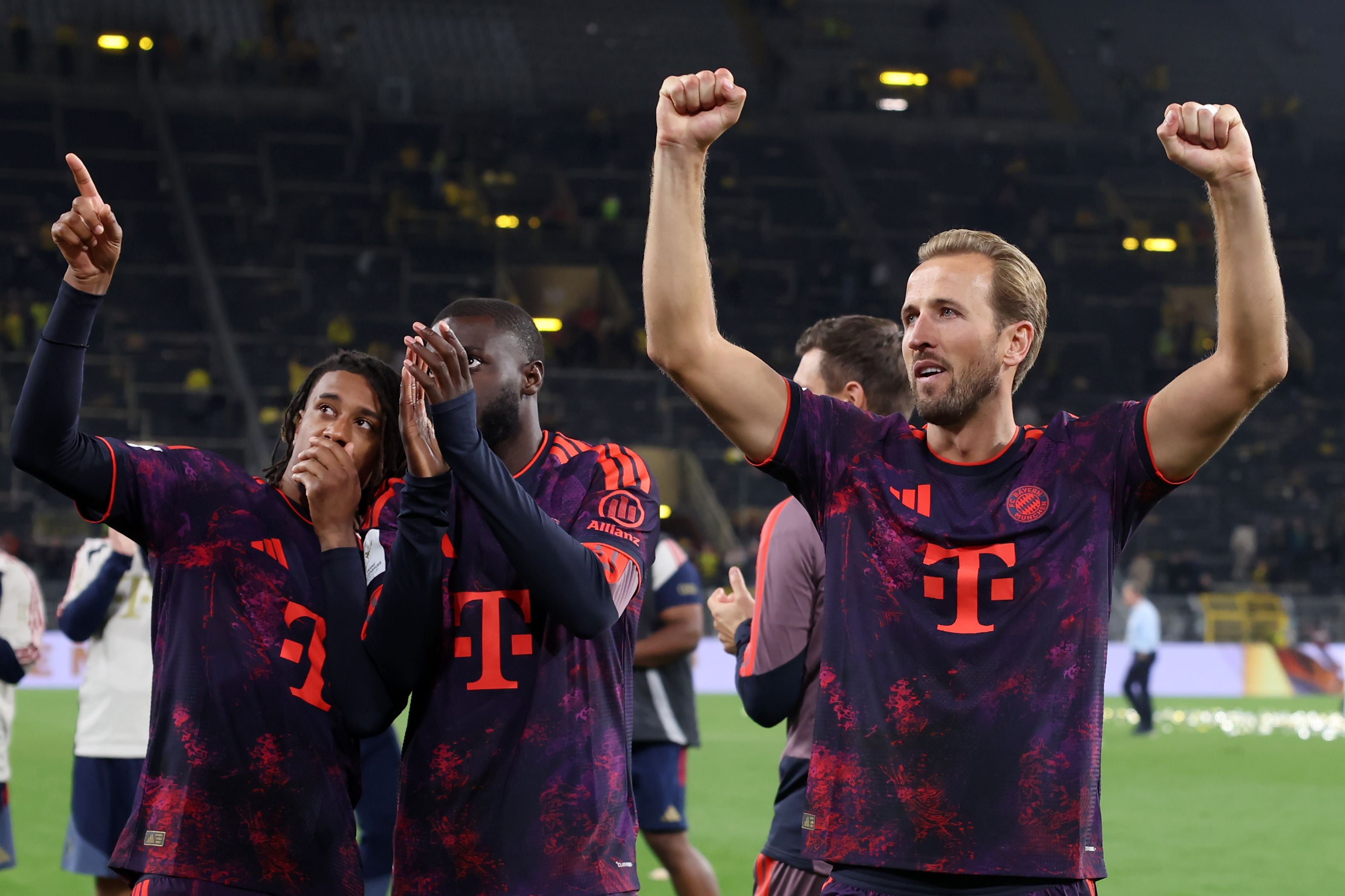 Bayern-Spieler jubeln im Stadion nach einem Fußballspiel, einer reckt die Arme nach oben.