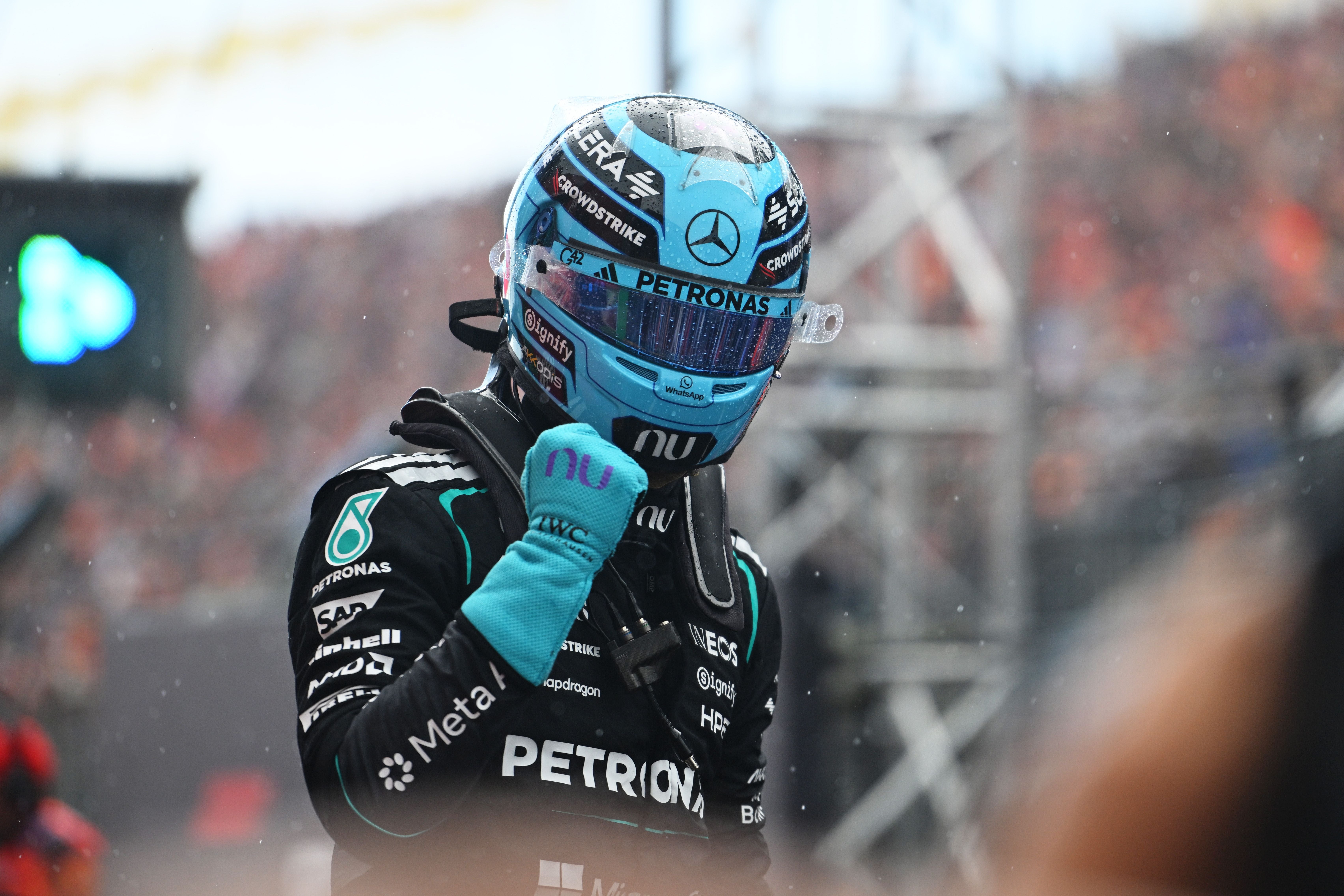 Ein Mercedes-F1-Fahrer feiert im Rennoverall und Helm mit geballter Faust in Zandvoort.
