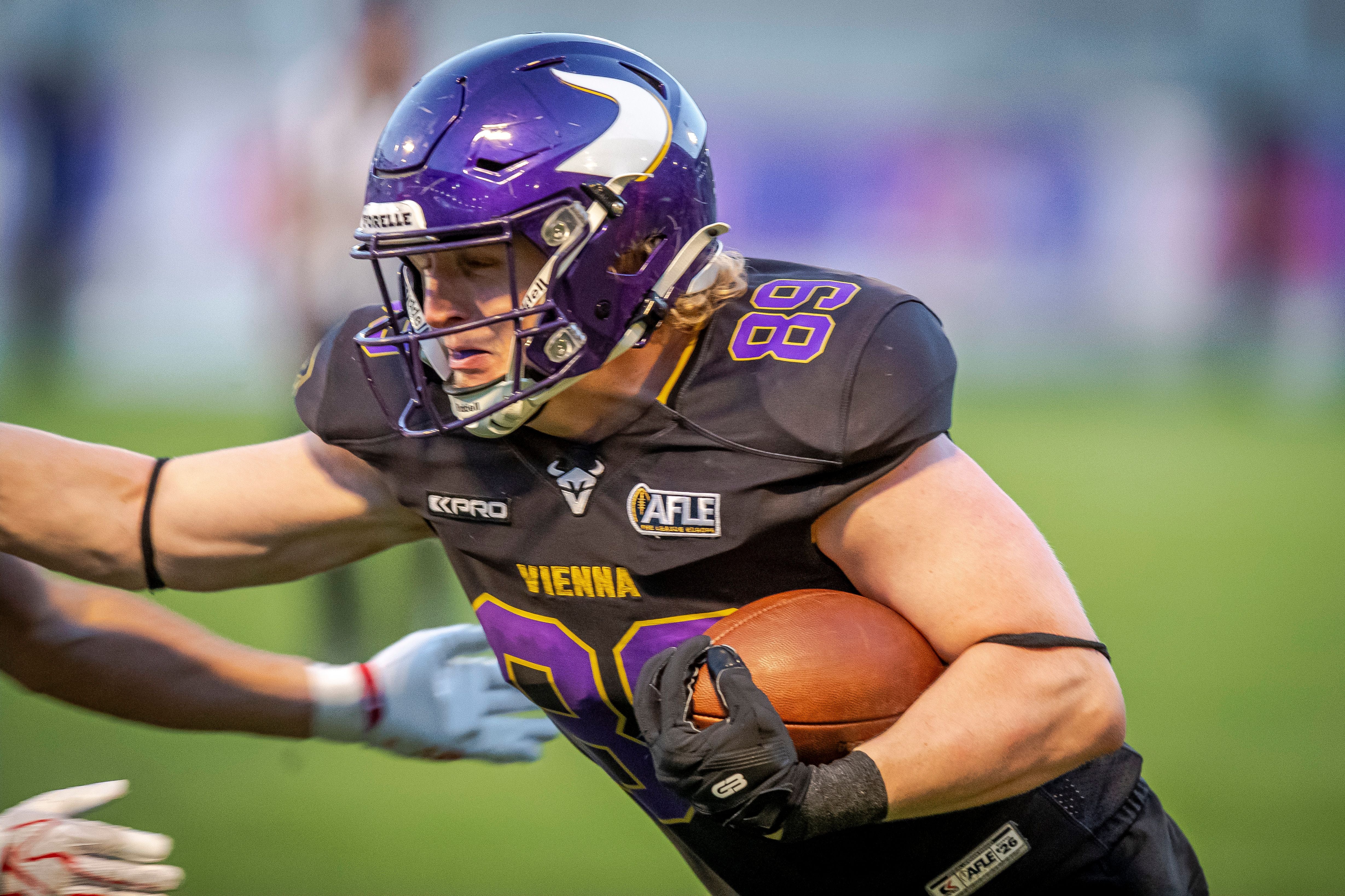 American-Football-Spieler der Vienna Vikings läuft mit dem Ball und trägt einen lila Helm.