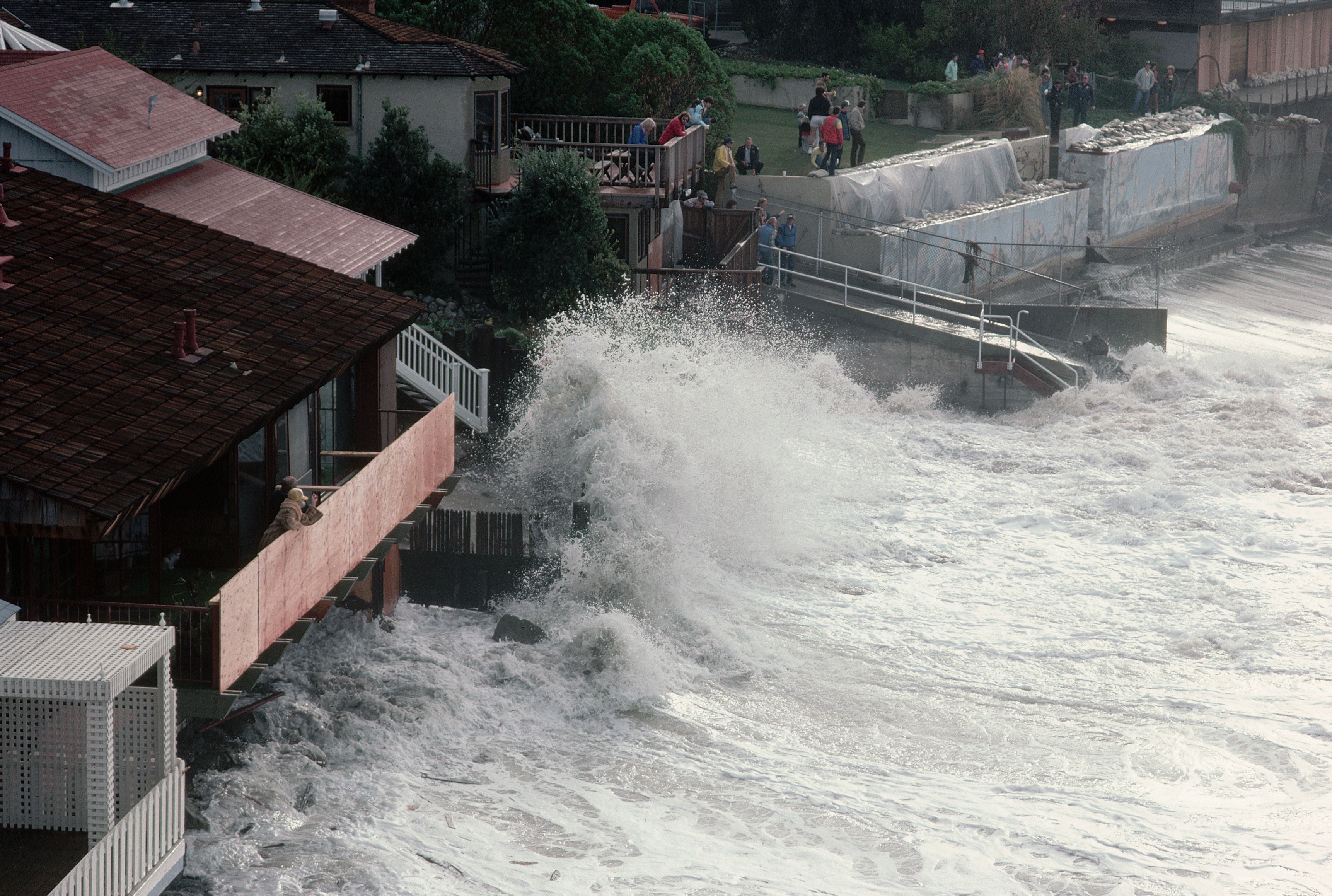 Große Wellen schlagen während eines Sturms gegen Häuser an der Küste von Laguna Beach.