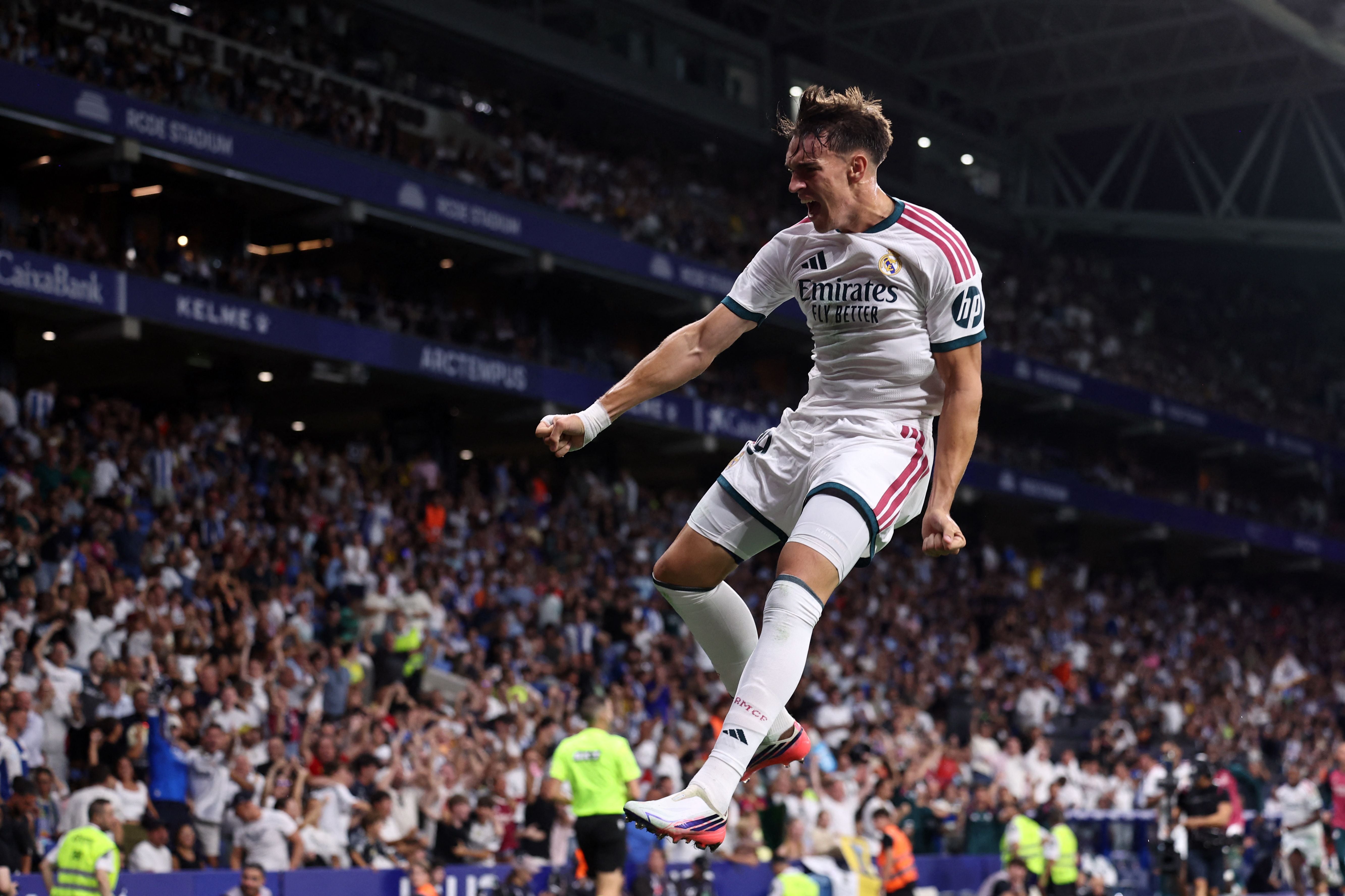 Ein Real-Madrid-Spieler jubelt nach einem Tor, springt mit geballter Faust vor jubilierendem Publikum.