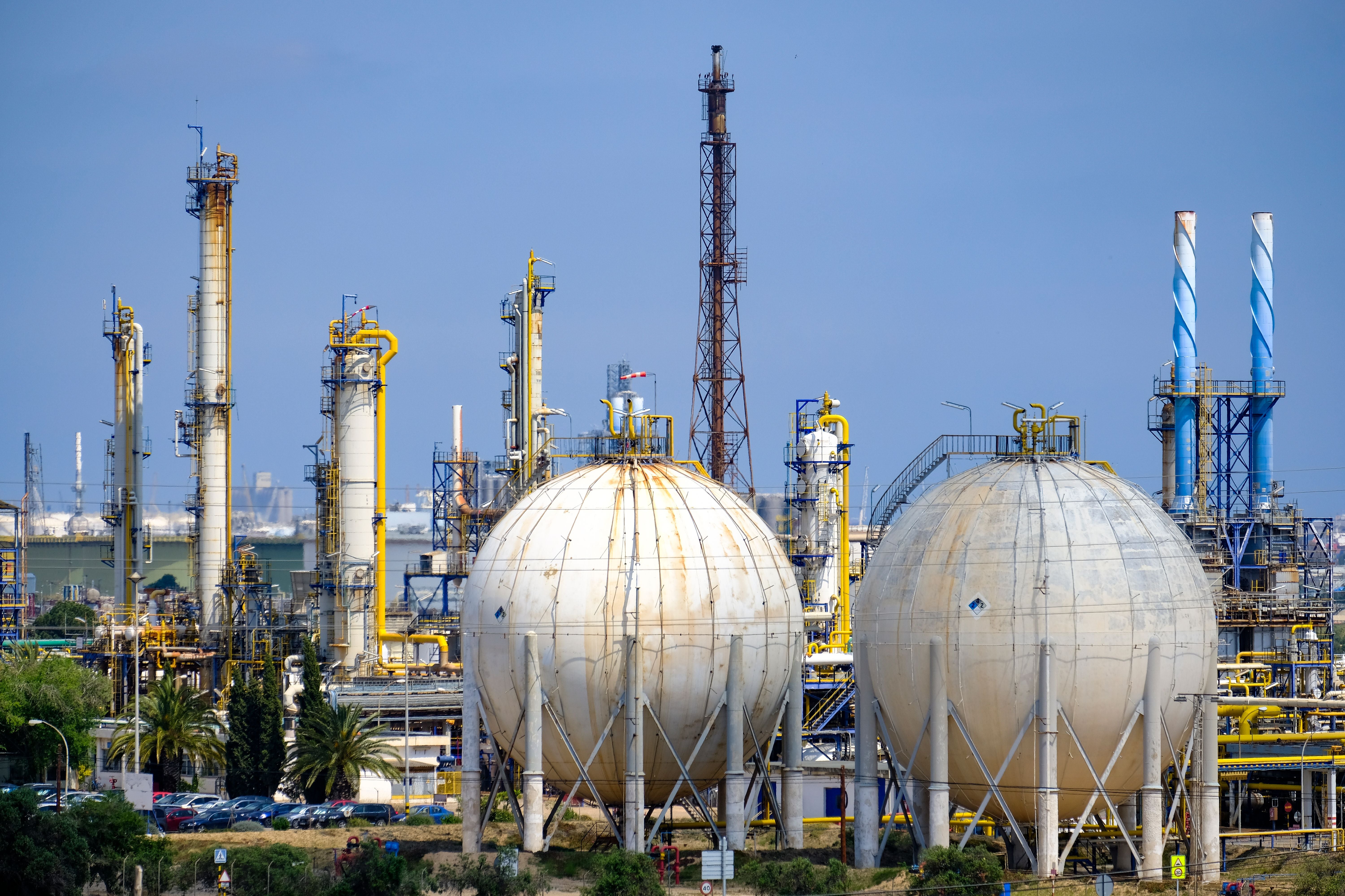 Petrochemischer Komplex mit kugelförmigen Tanks und Industrieanlagen unter blauem Himmel.