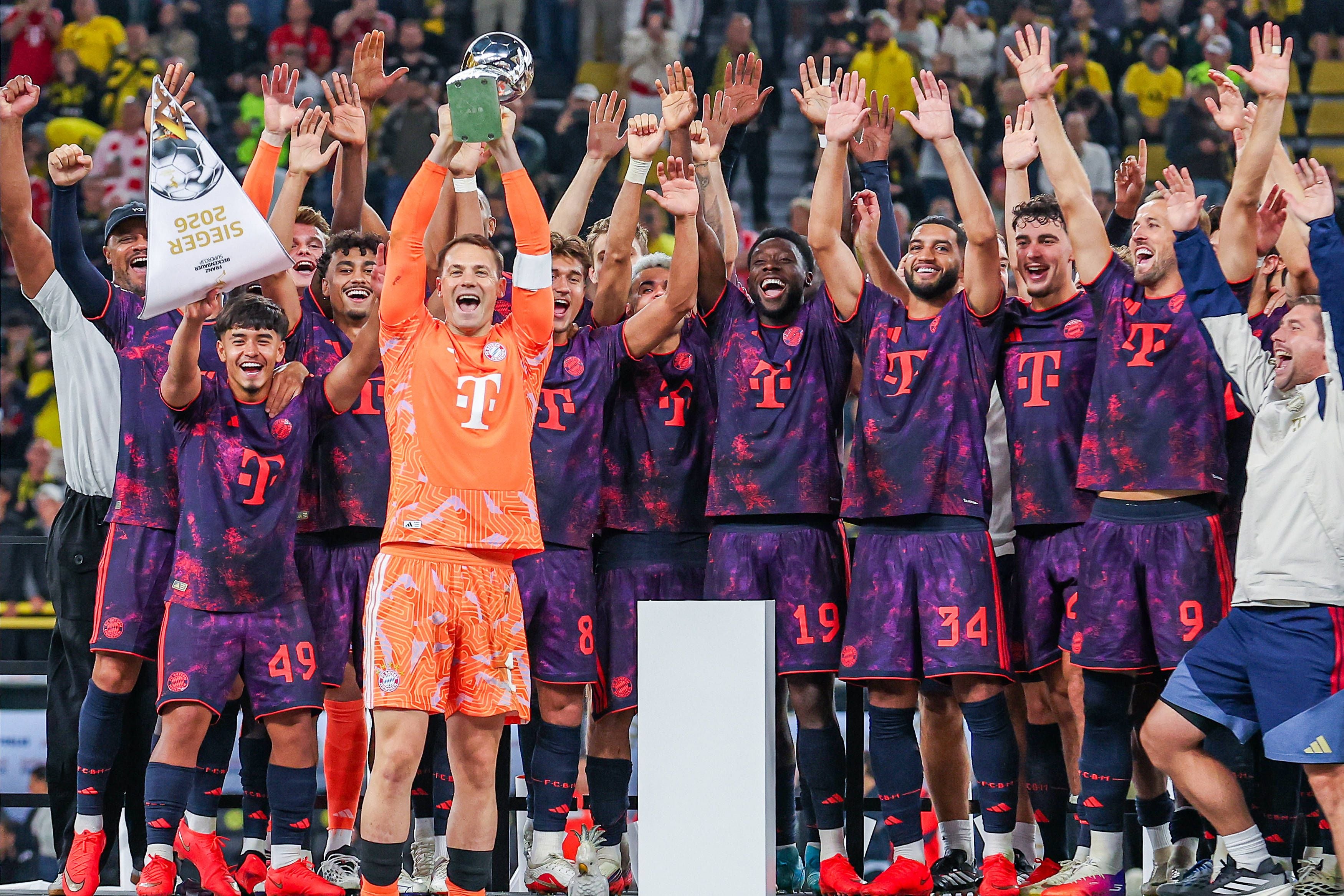 Die Spieler des FC Bayern München jubeln mit dem Supercup-Pokal im Stadion.