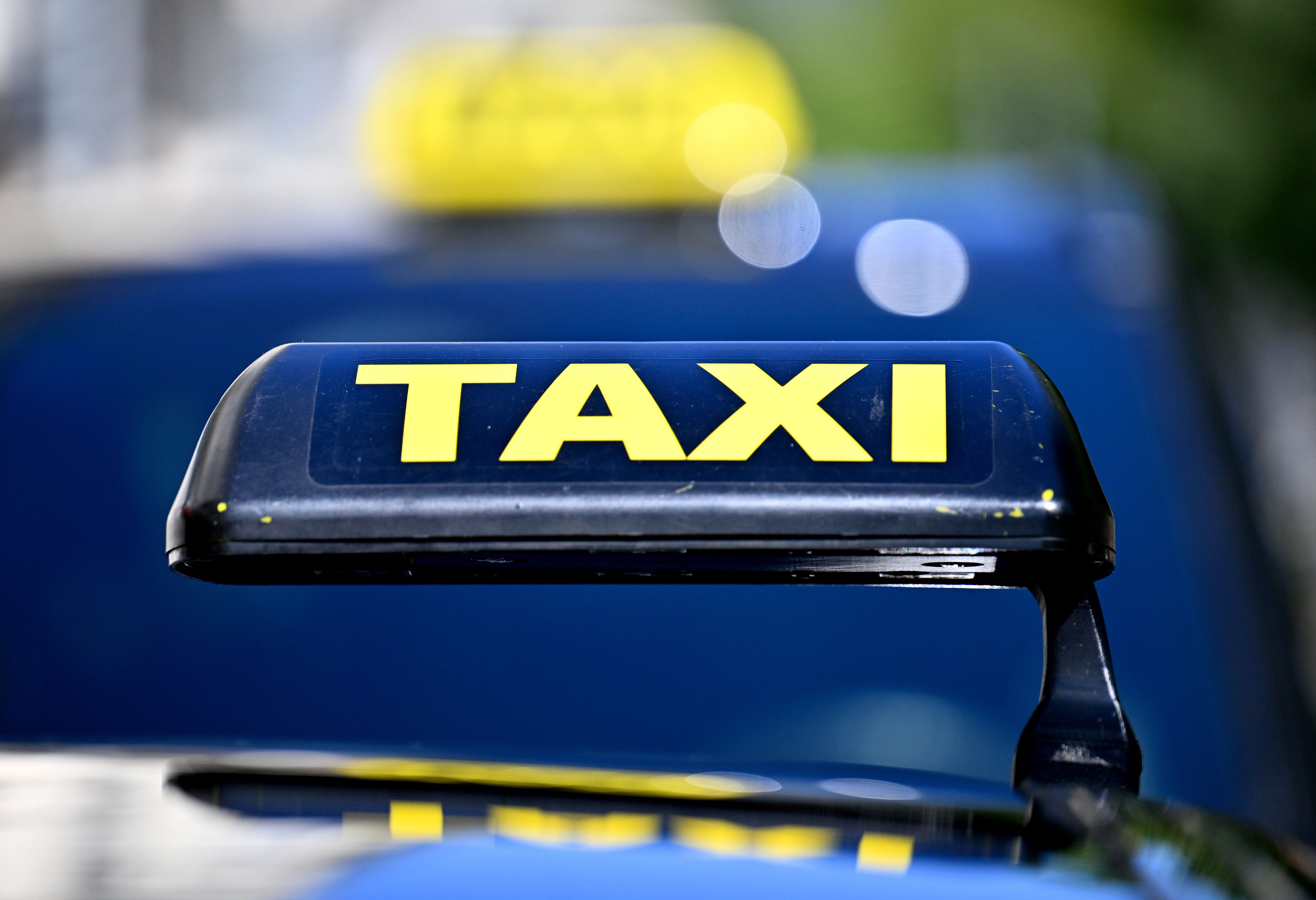 Nahaufnahme eines gelben Taxi-Schilds auf einem Auto in Wien bei Tageslicht.