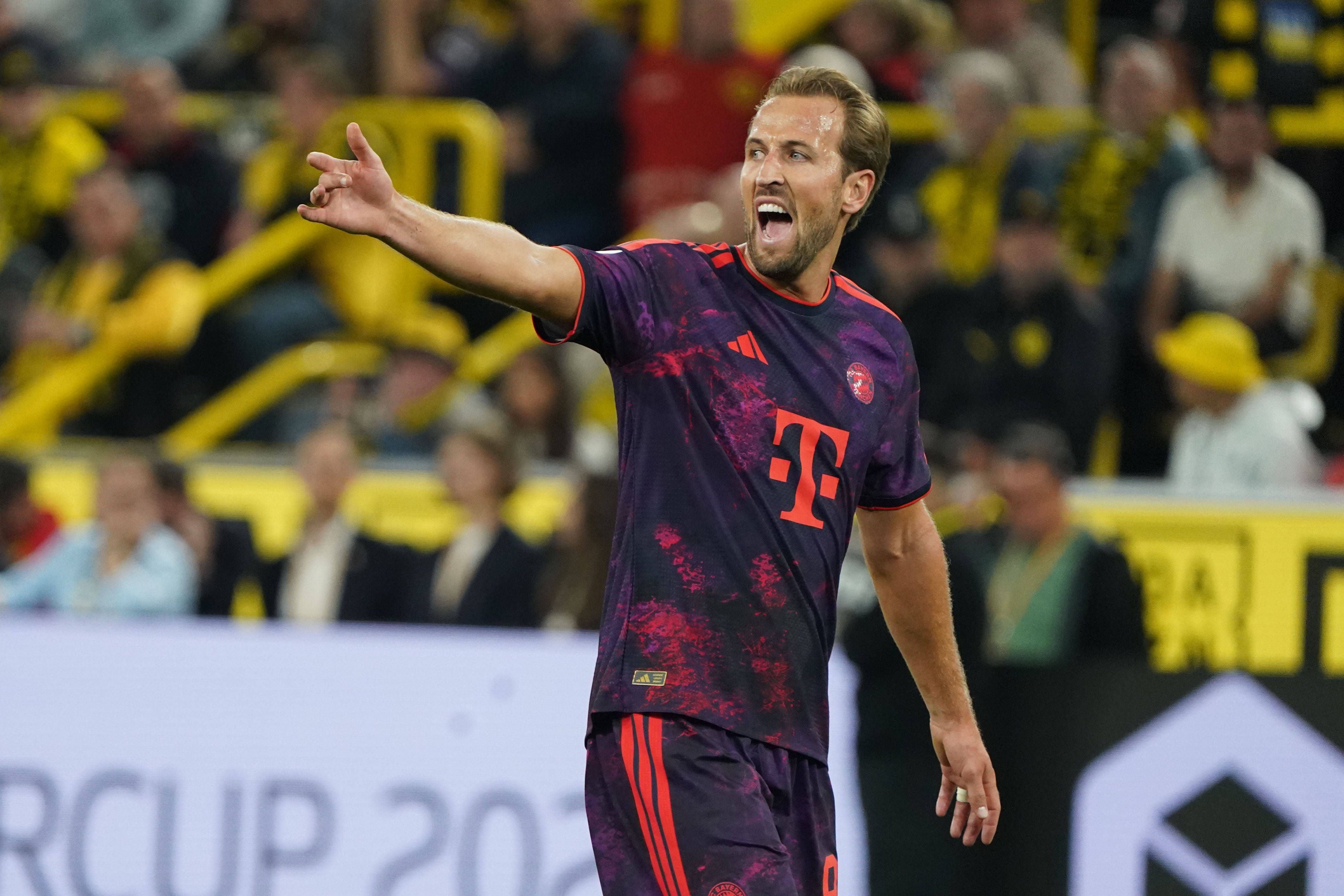 Fußballspieler im lila Trikot des FC Bayern München gestikuliert auf dem Spielfeld.