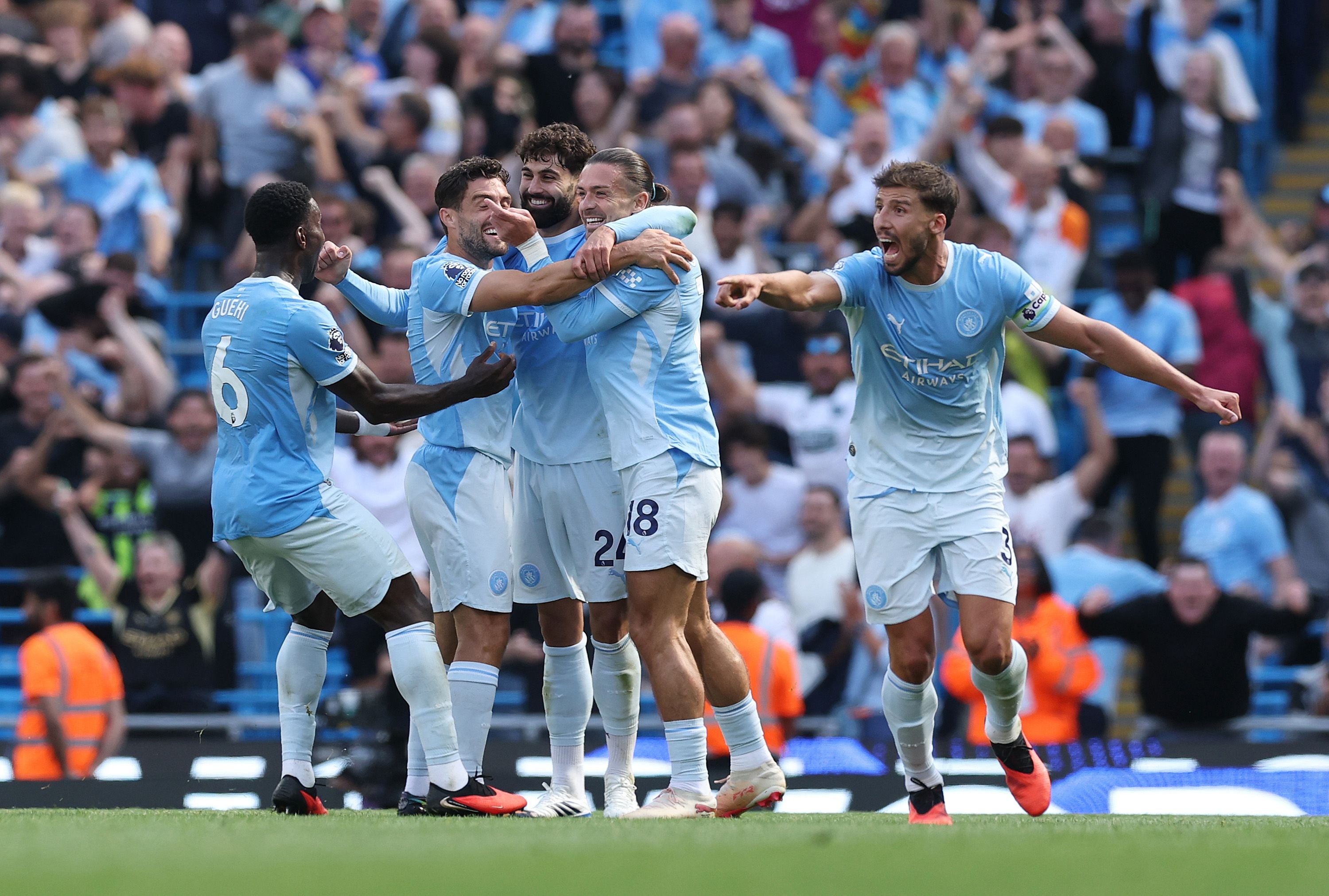 Mehrere Fußballspieler von Manchester City feiern gemeinsam ein Tor auf dem Spielfeld.