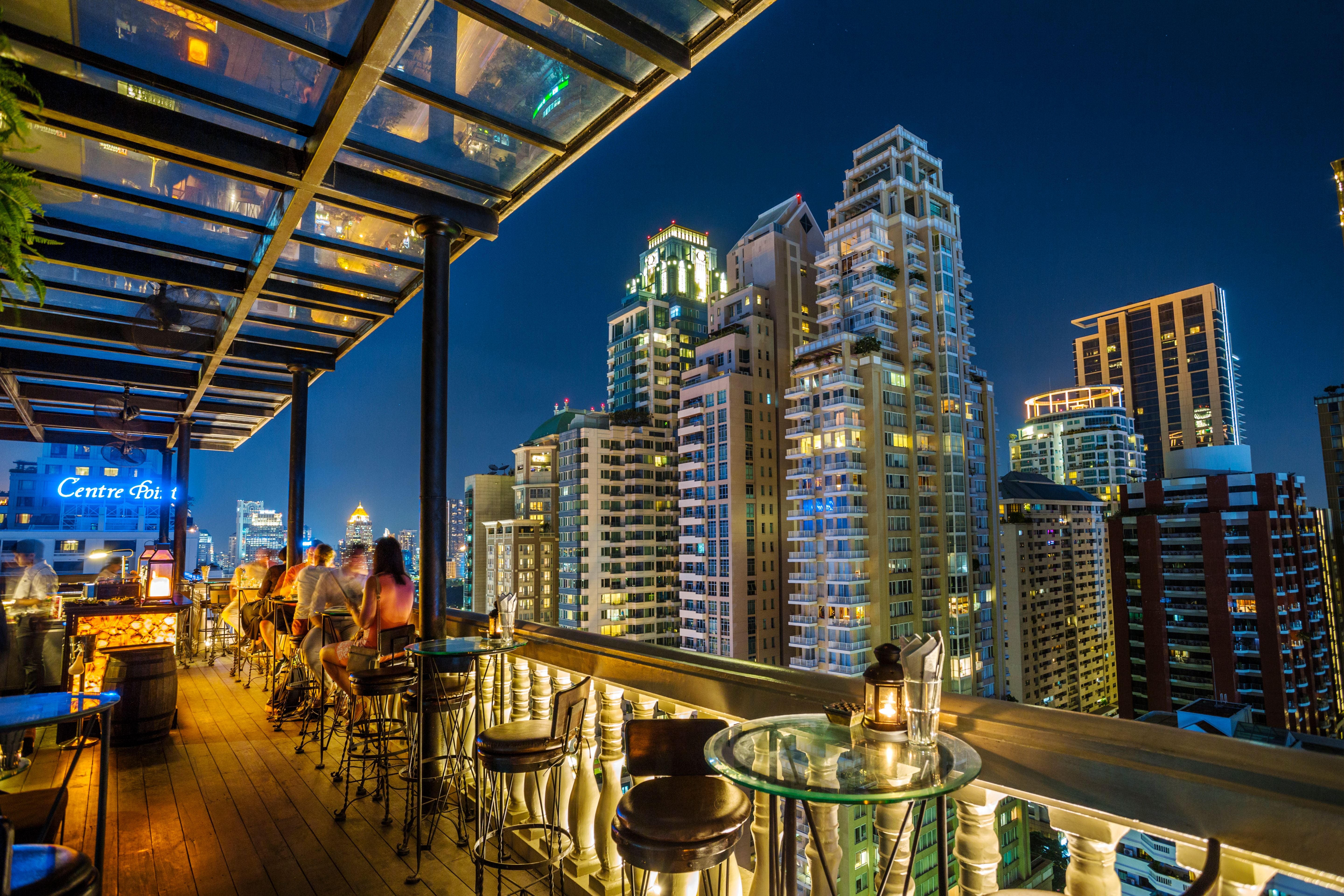 Rooftop-Barterrasse mit Blick auf die Skyline von Bangkok bei Nacht im Lumphini-Viertel.