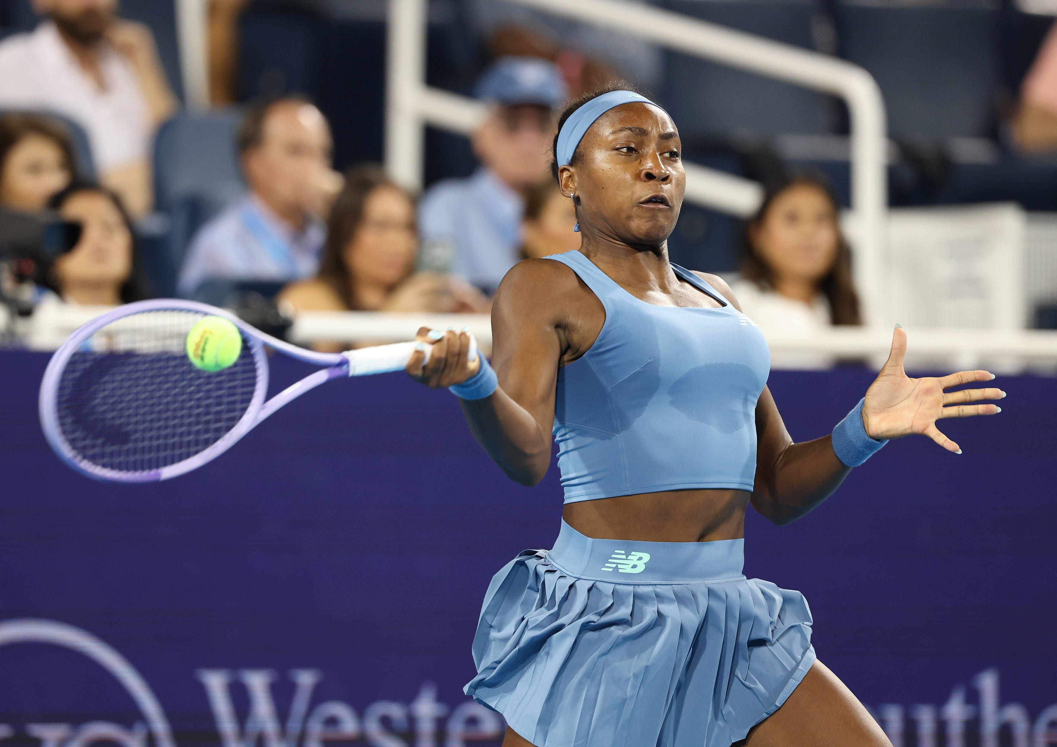 Coco Gauff im blauen Sporttop schlägt auf dem Hartplatz eine Vorhand.