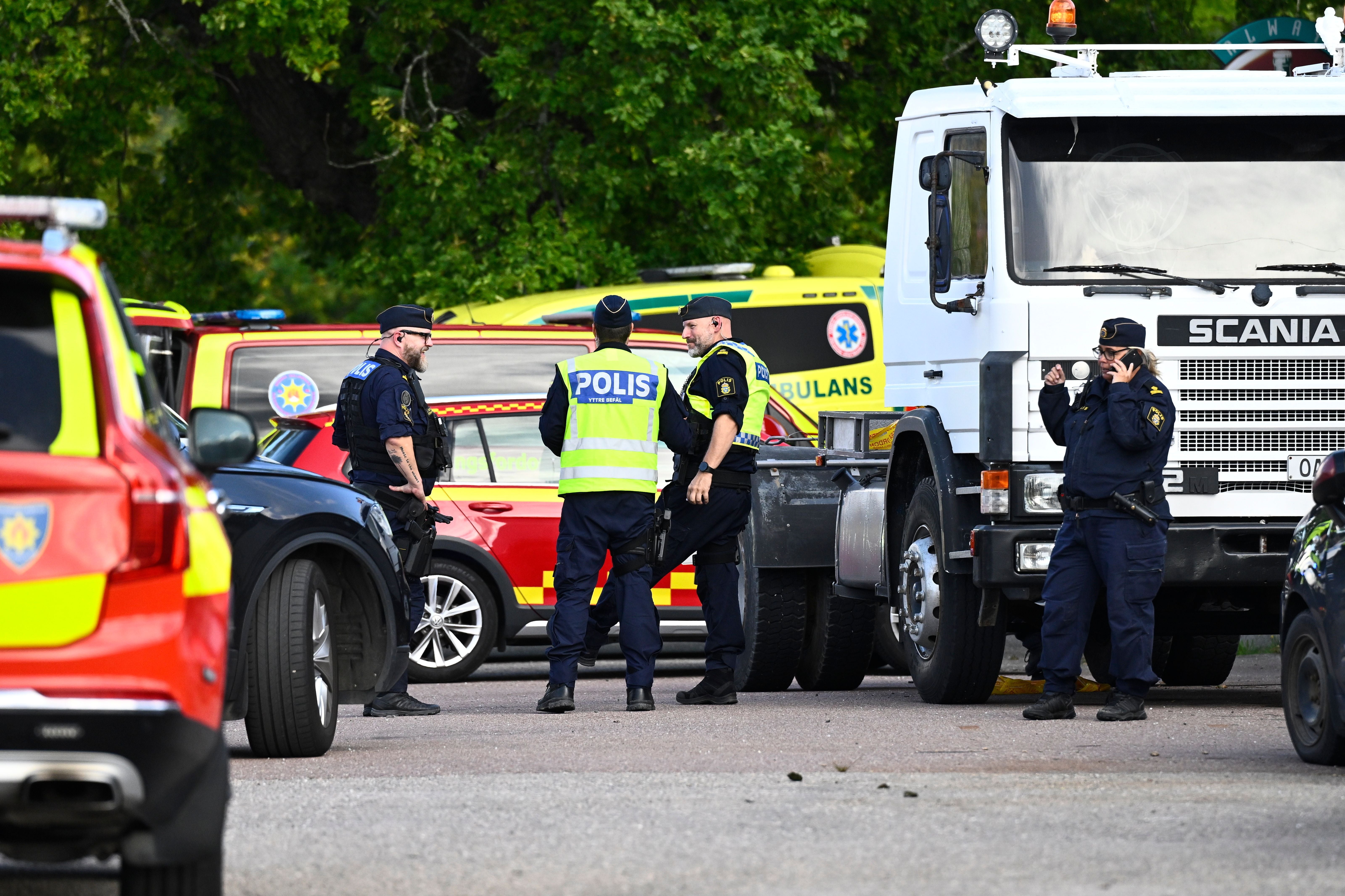 Polizei und Rettungskräfte stehen bei einer Einsatzstelle mit mehreren Einsatzfahrzeugen in Schweden.