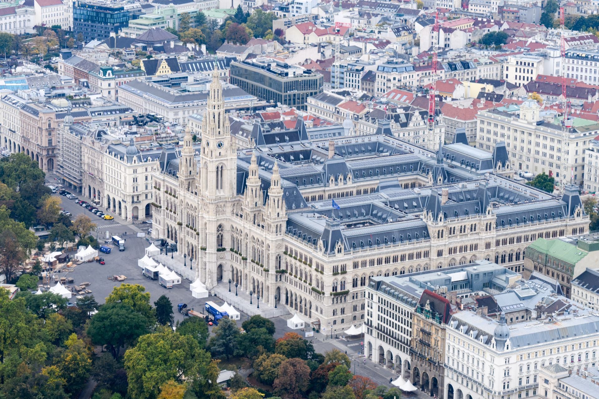 Luftaufnahme des Wiener Rathauses mit umliegenden Häusern und Bäumen im Herbst.