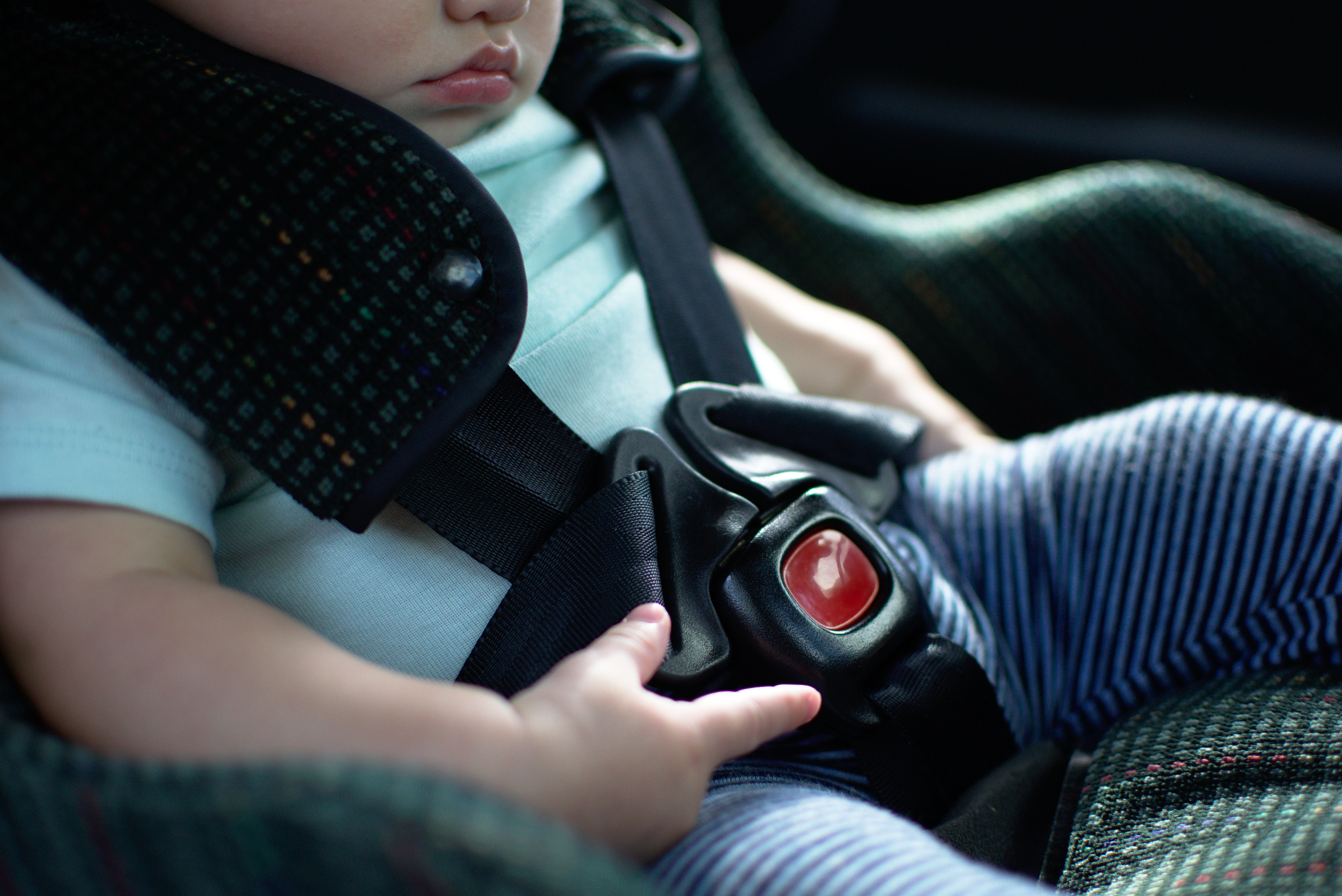 Baby sitzt angeschnallt in einem nach hinten gerichteten Kindersitz im Auto.