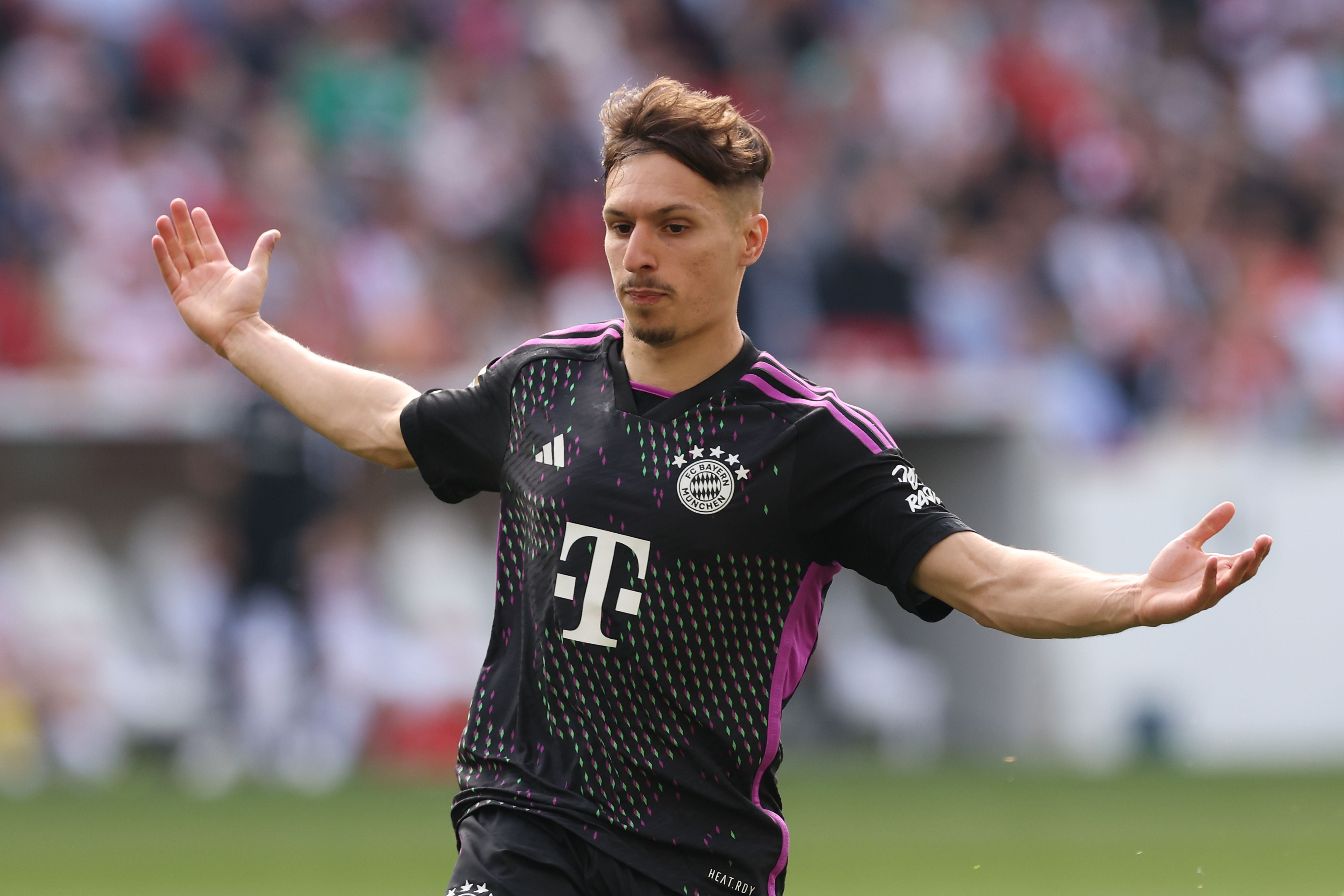 Ein FC Bayern-Spieler breitet im Spiel gegen Stuttgart die Arme aus und wirkt nachdenklich.
