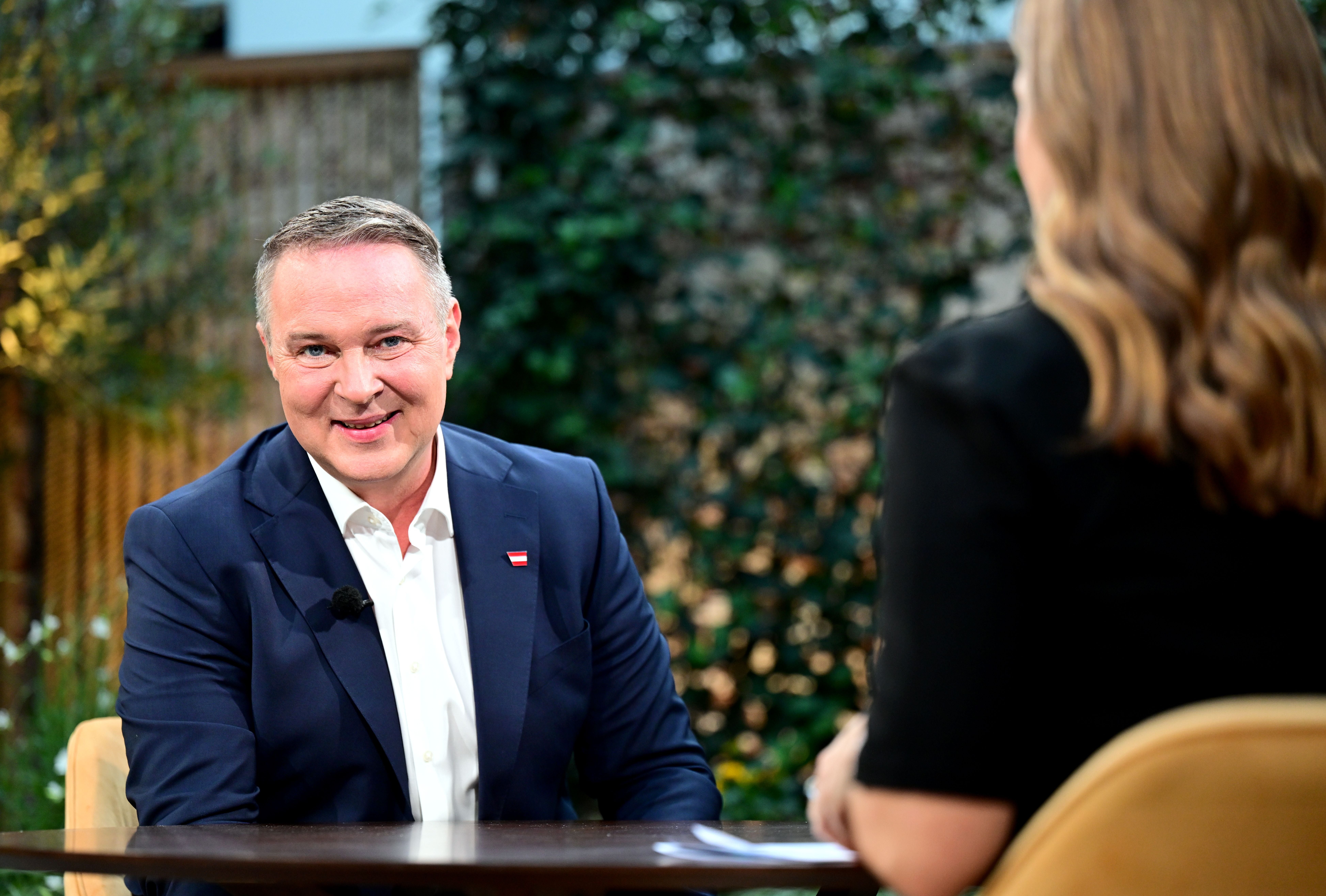 Andreas Babler im Gespräch mit Simone Stribl in einem Fernsehstudio mit grünem Hintergrund.