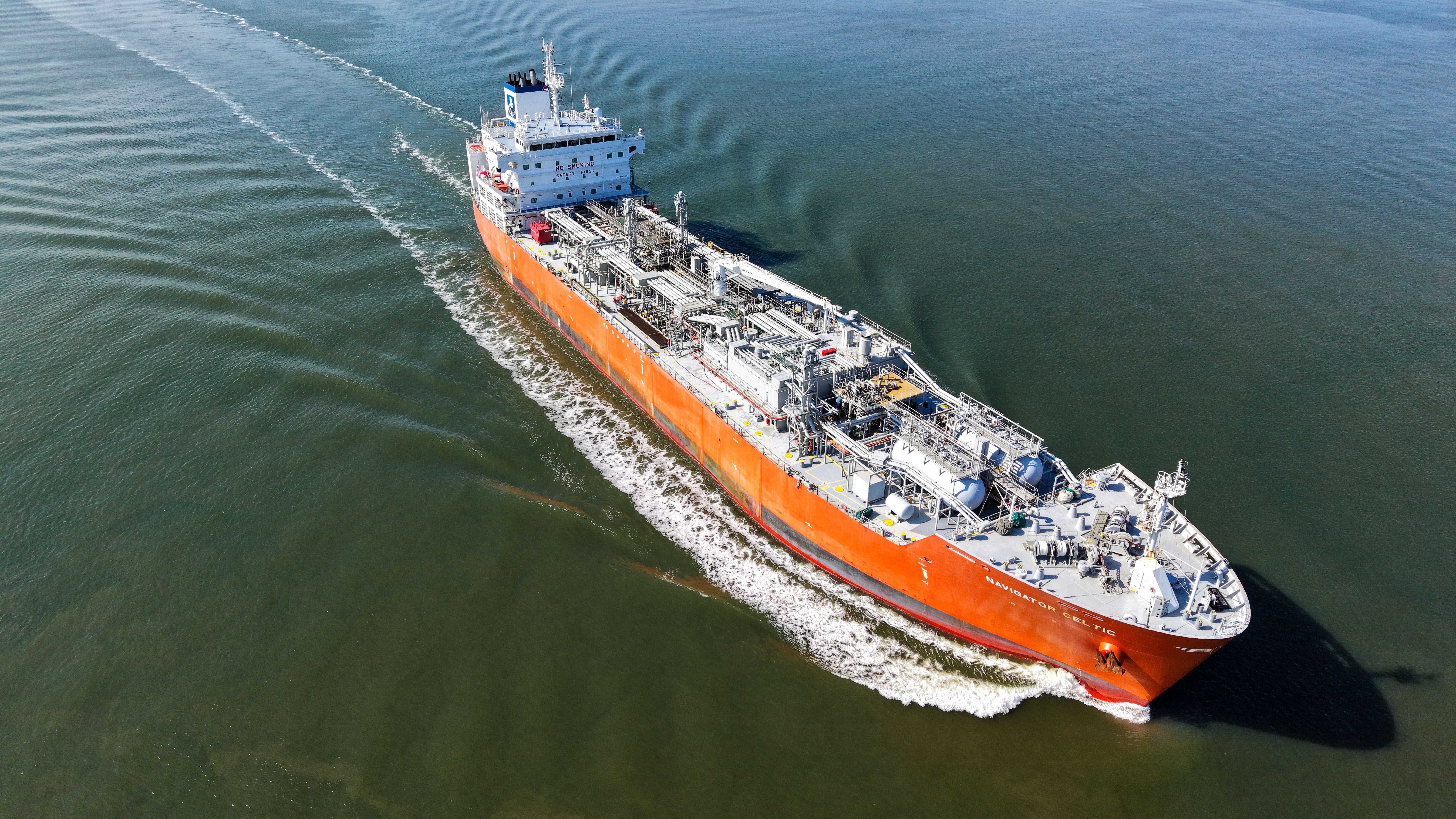 Das rote LPG-Tankschiff Navigator Celtic fährt auf dem Fluss Schelde in sonnigem Wetter.