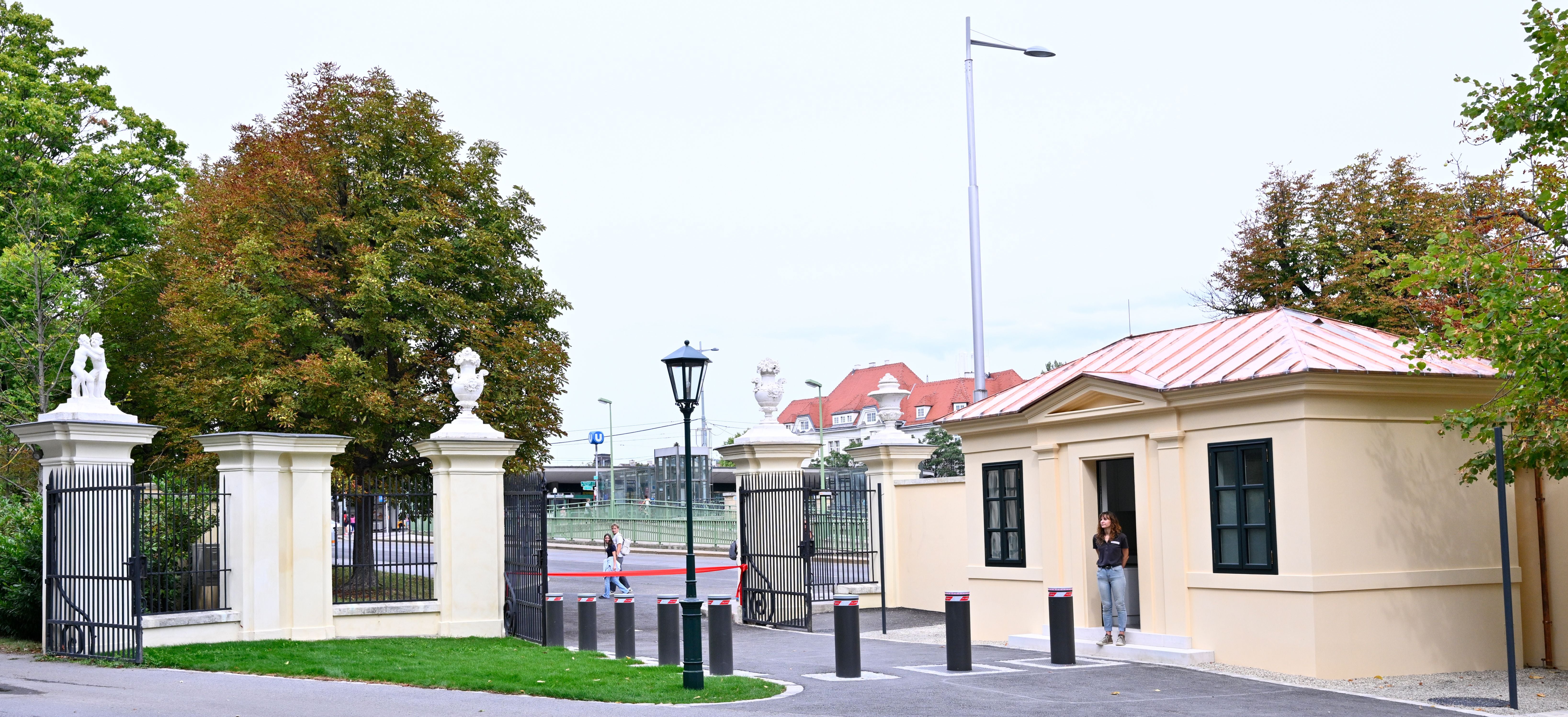 Das Engelstor am Schlosspark Schönbrunn mit geöffnetem Tor und Menschen im Eingangsbereich.